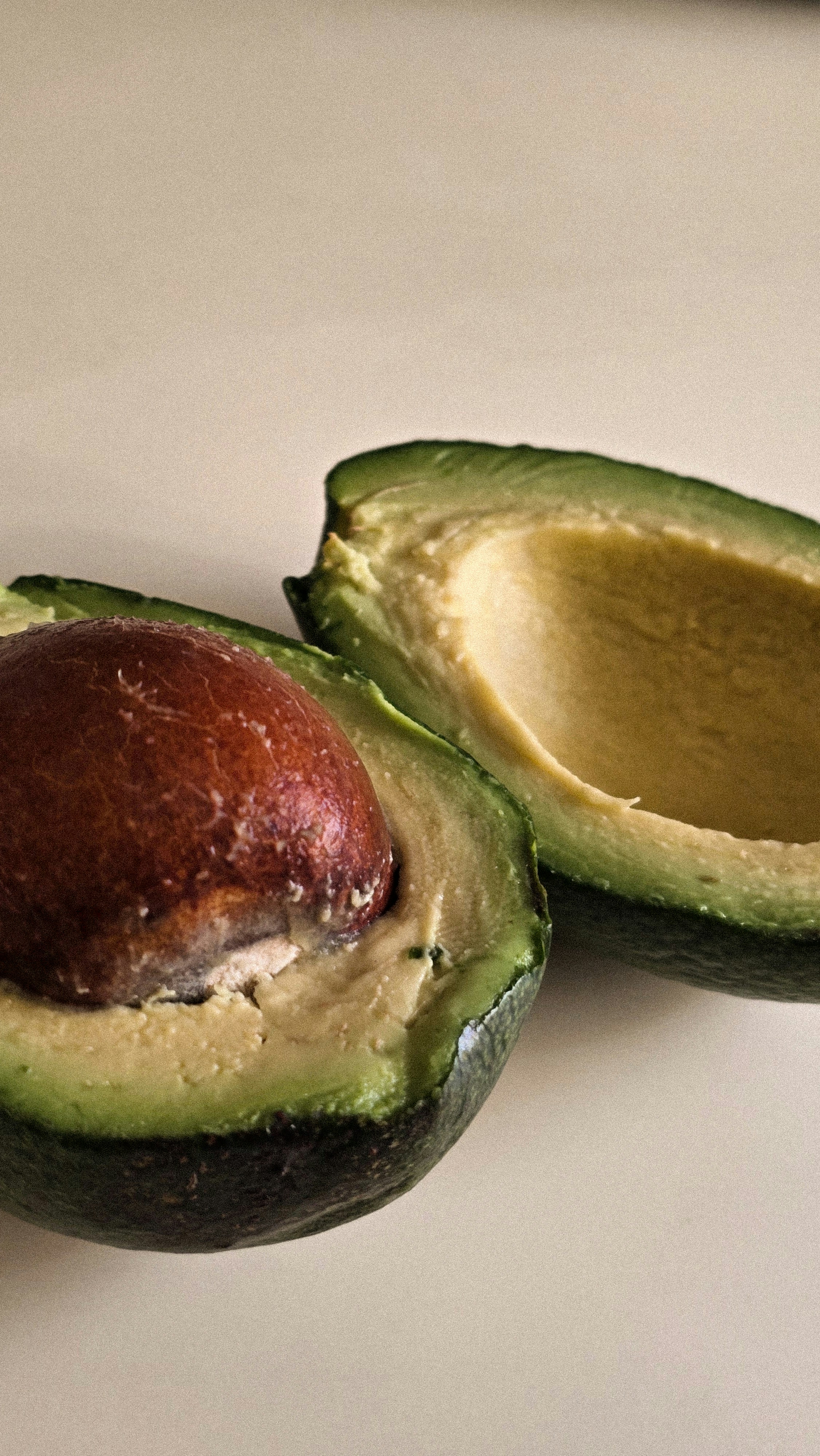 An avocado cut in half sitting on a counter