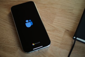 A cell phone sitting on top of a wooden table