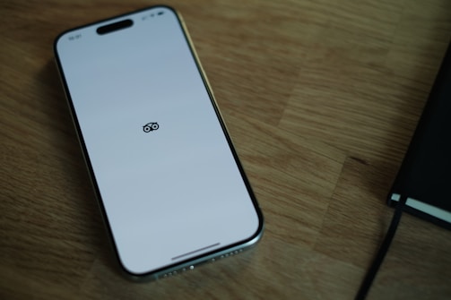 A cell phone sitting on top of a wooden table
