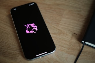 A cell phone with a pink unicorn sticker on it