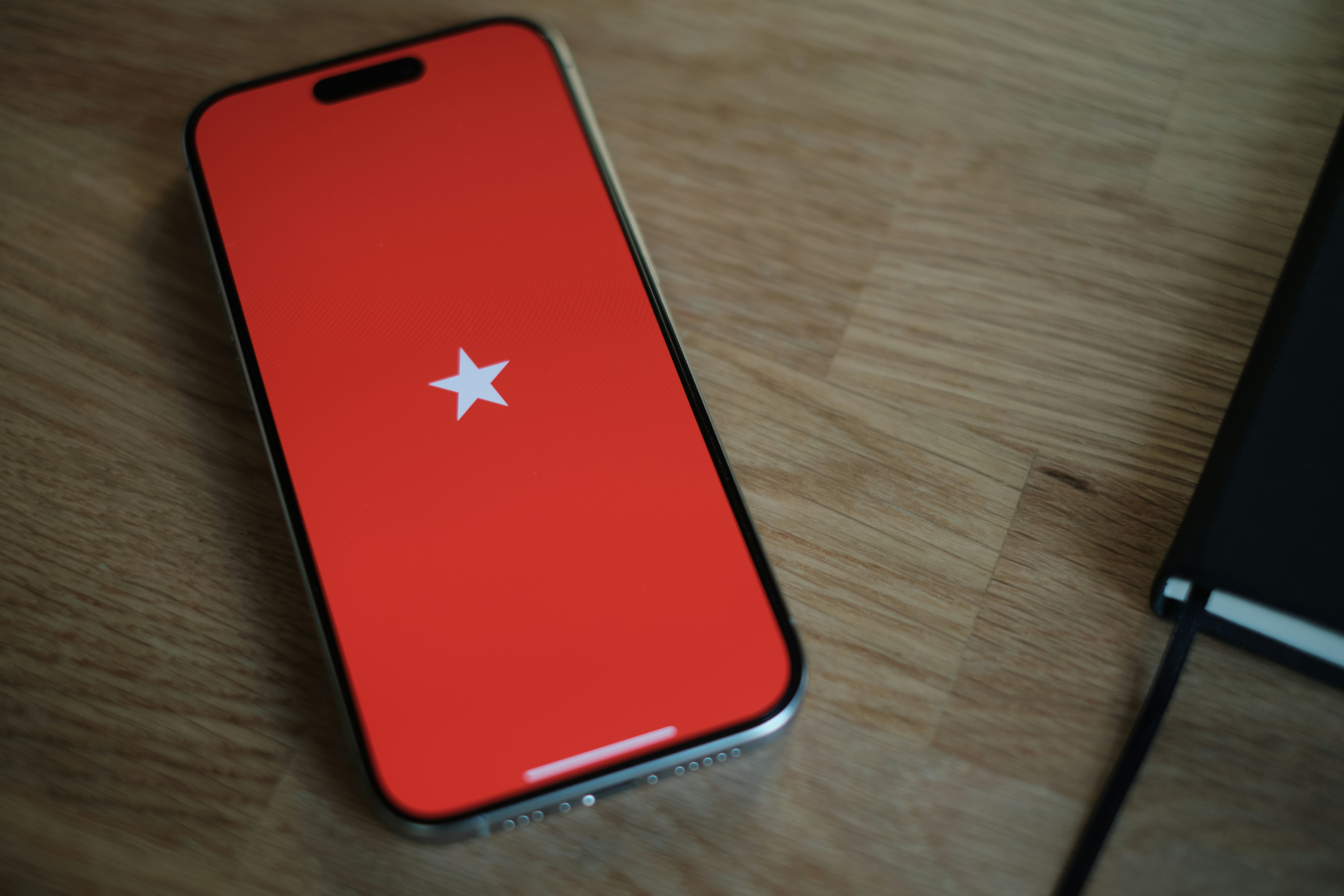 Red cell phone on wooden table