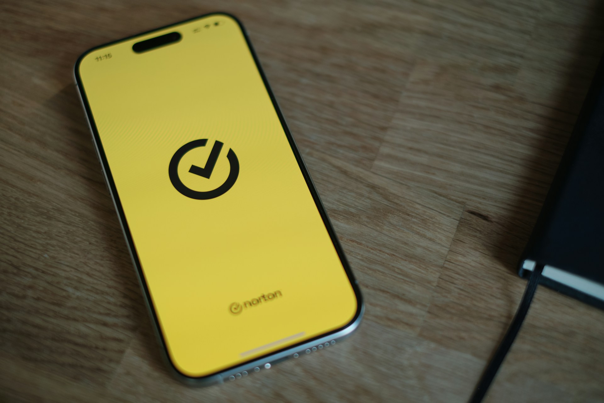 A yellow cell phone sitting on top of a wooden table