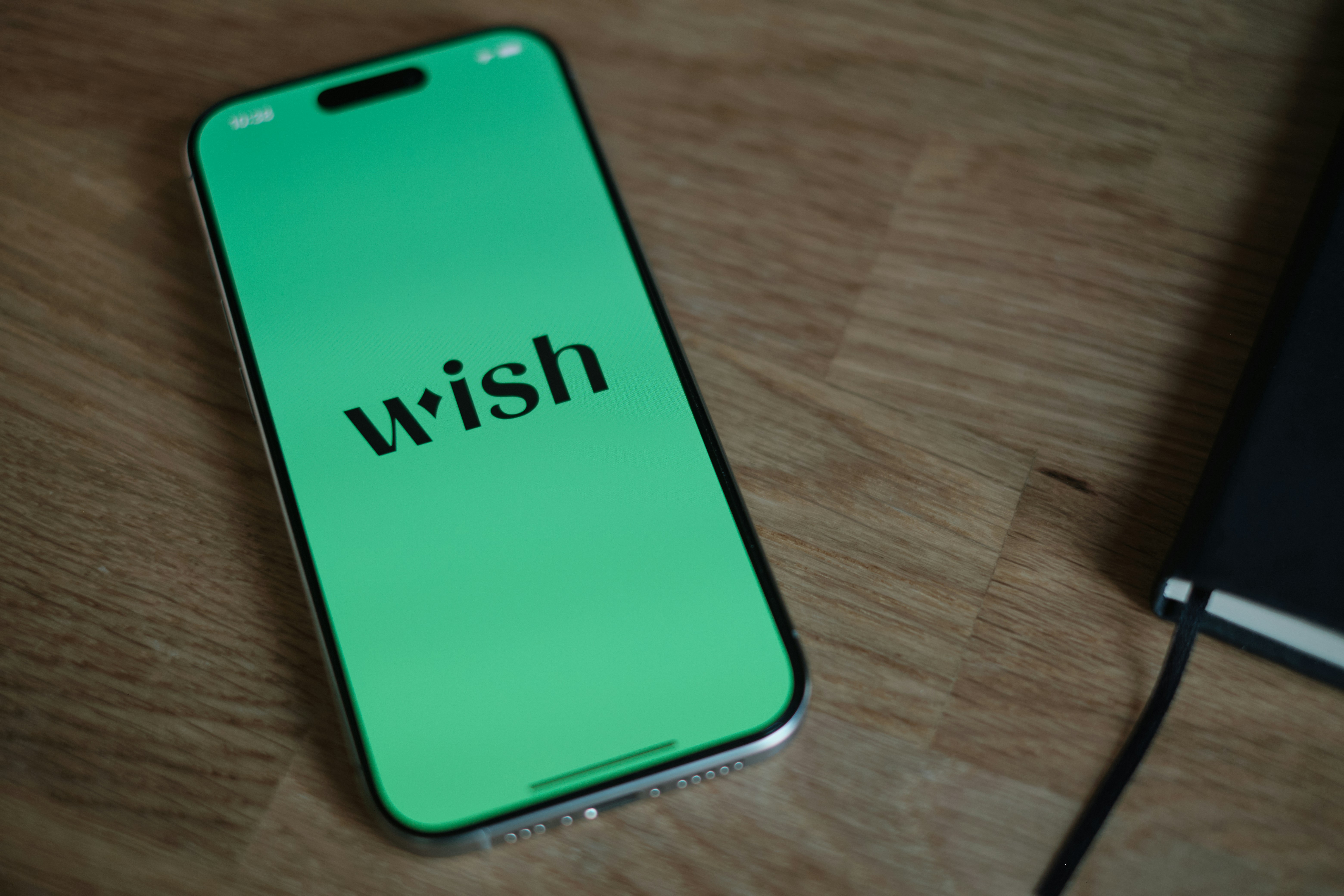 A green phone sitting on top of a wooden table