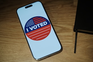 A cell phone with a vote sticker on it