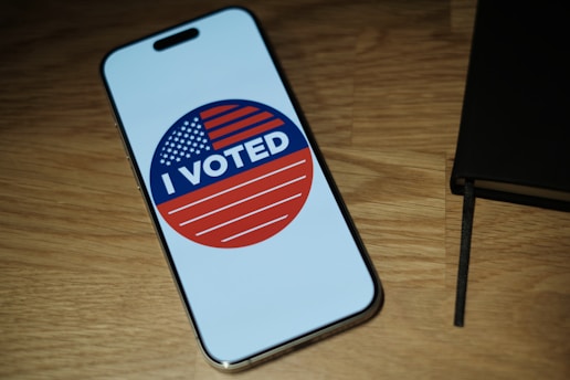 A cell phone with a vote sticker on it