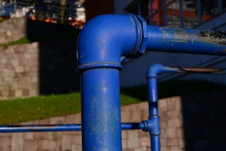 A blue pipe on the side of a building
