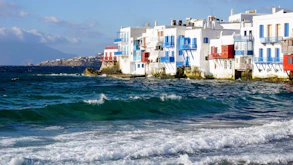 A row of houses sitting on top of a beach next to the ocean
