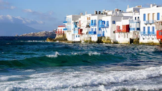 A row of houses sitting on top of a beach next to the ocean