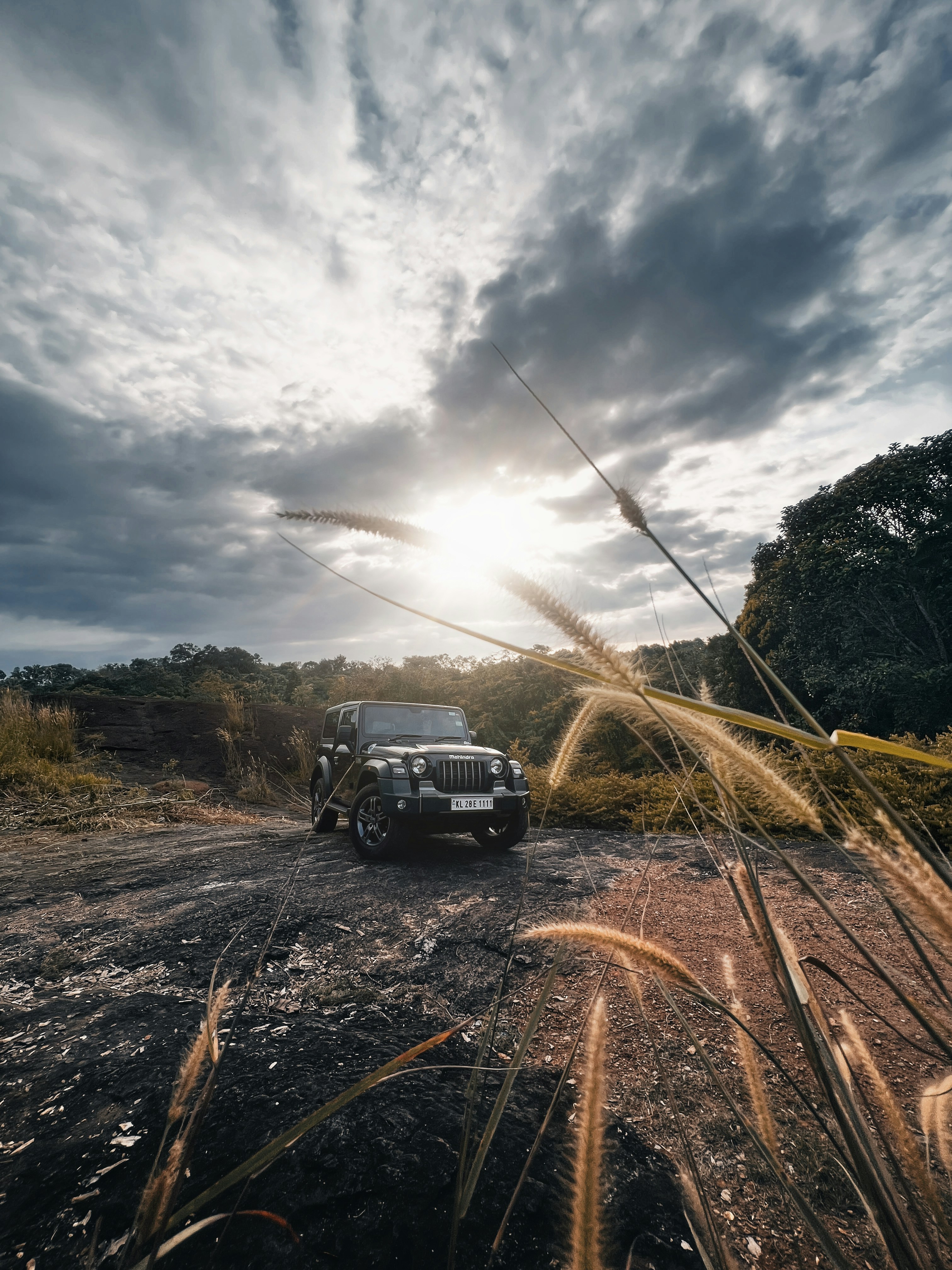 Un jeep conduciendo por un camino de tierra bajo un cielo nublado