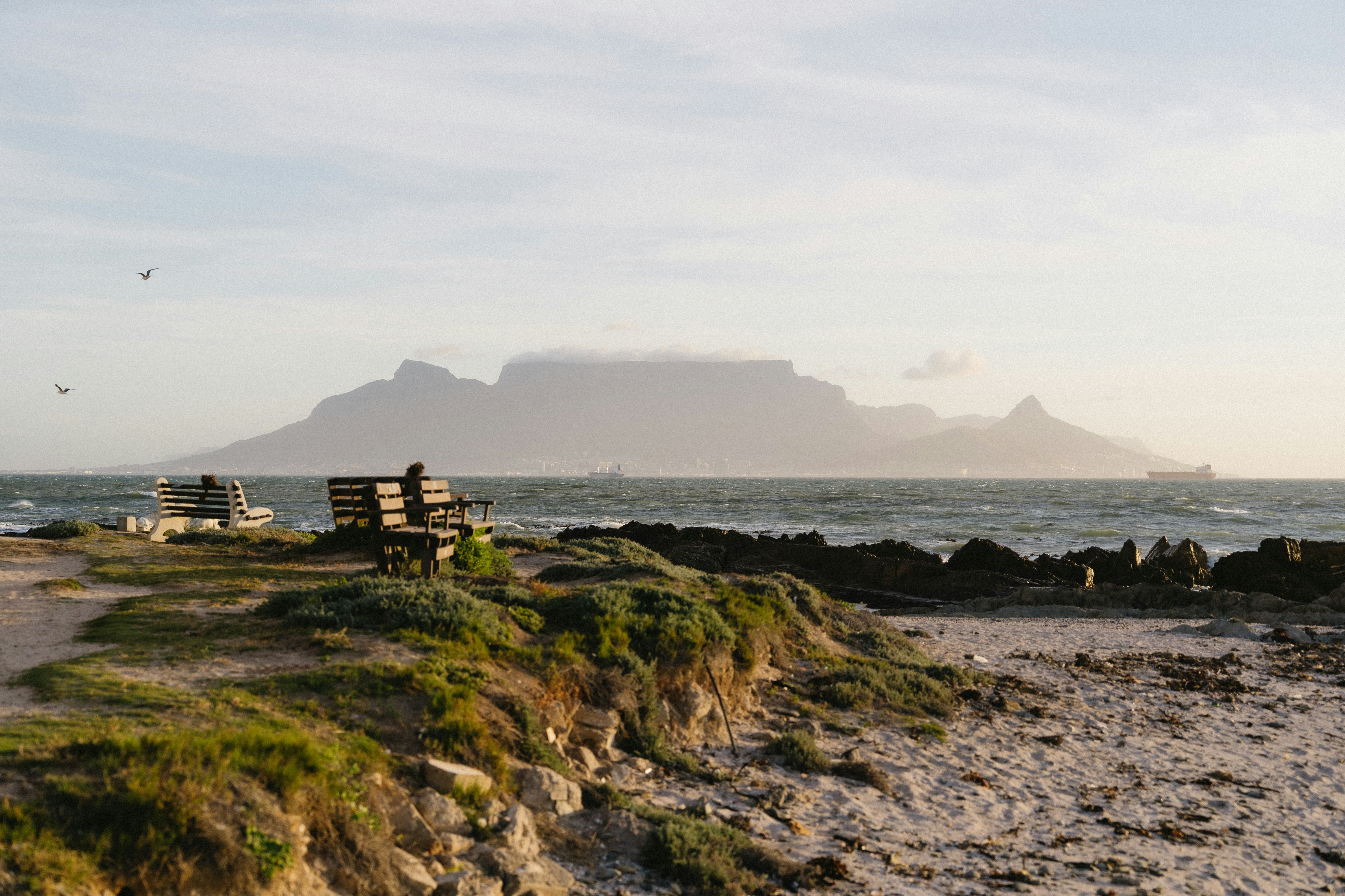 A bench on a beach near the ocean photo – Free Sky Image on Unsplash