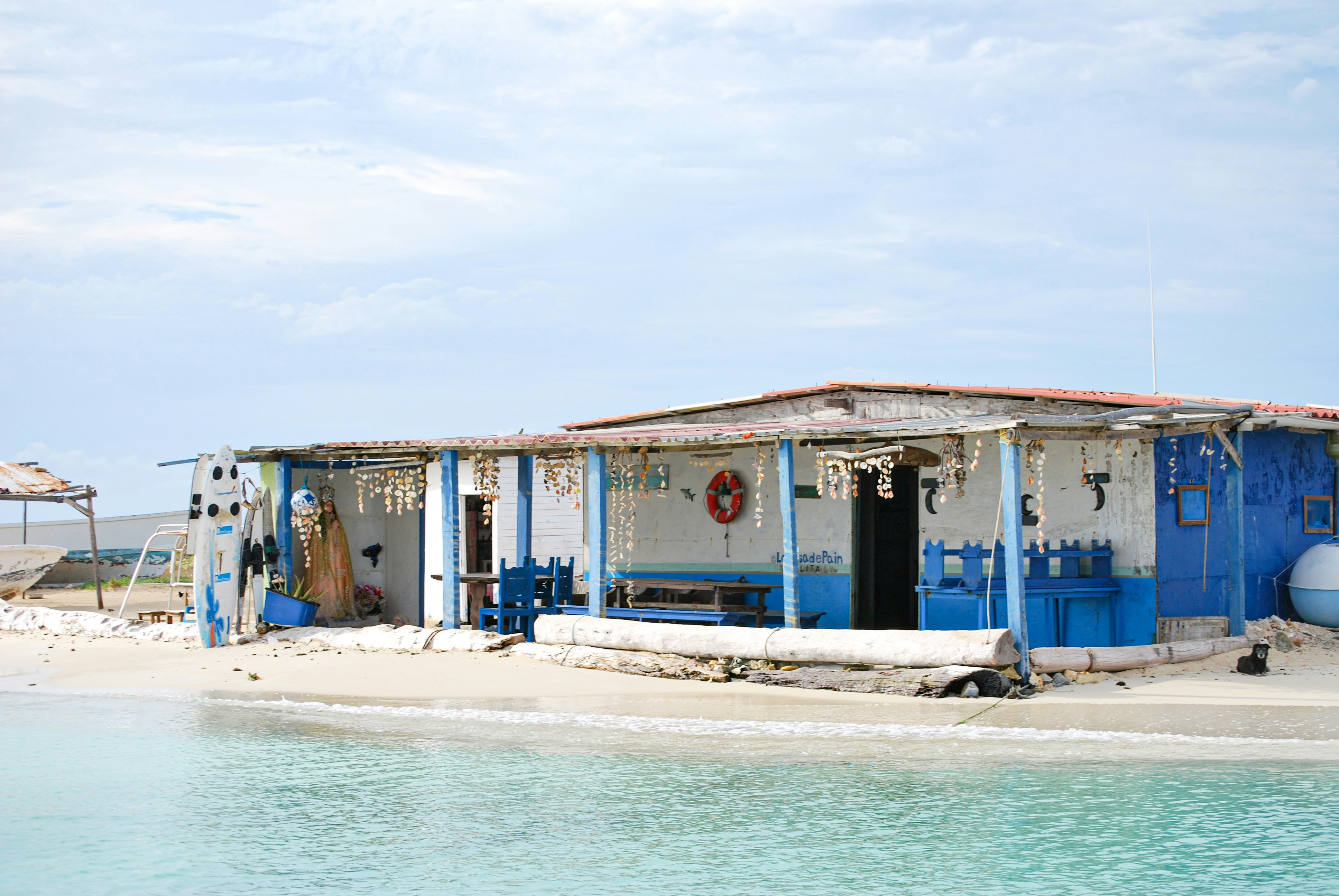 A blue and white building sitting on top of a beach