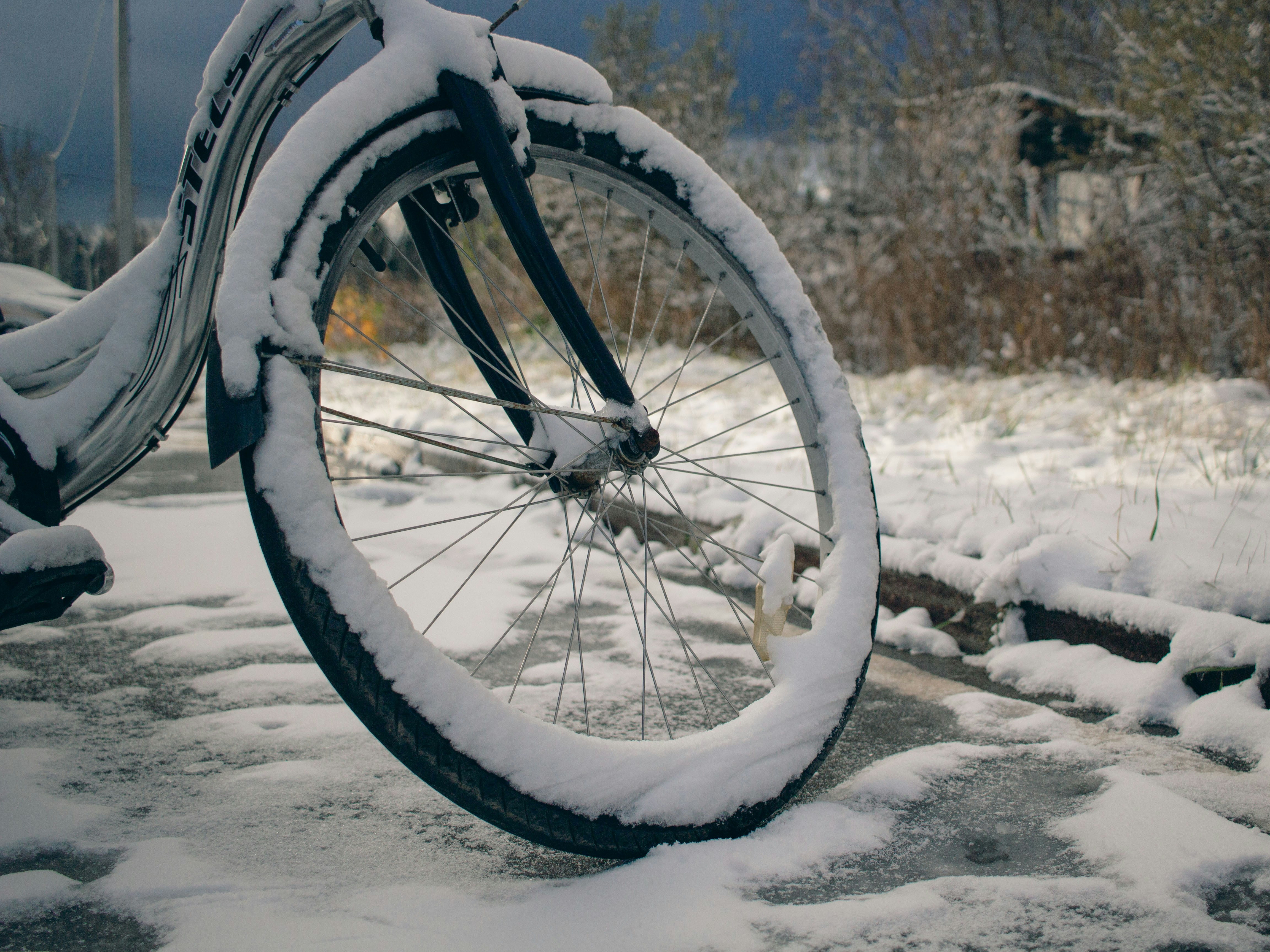 A bicycle is covered in snow on a snowy day