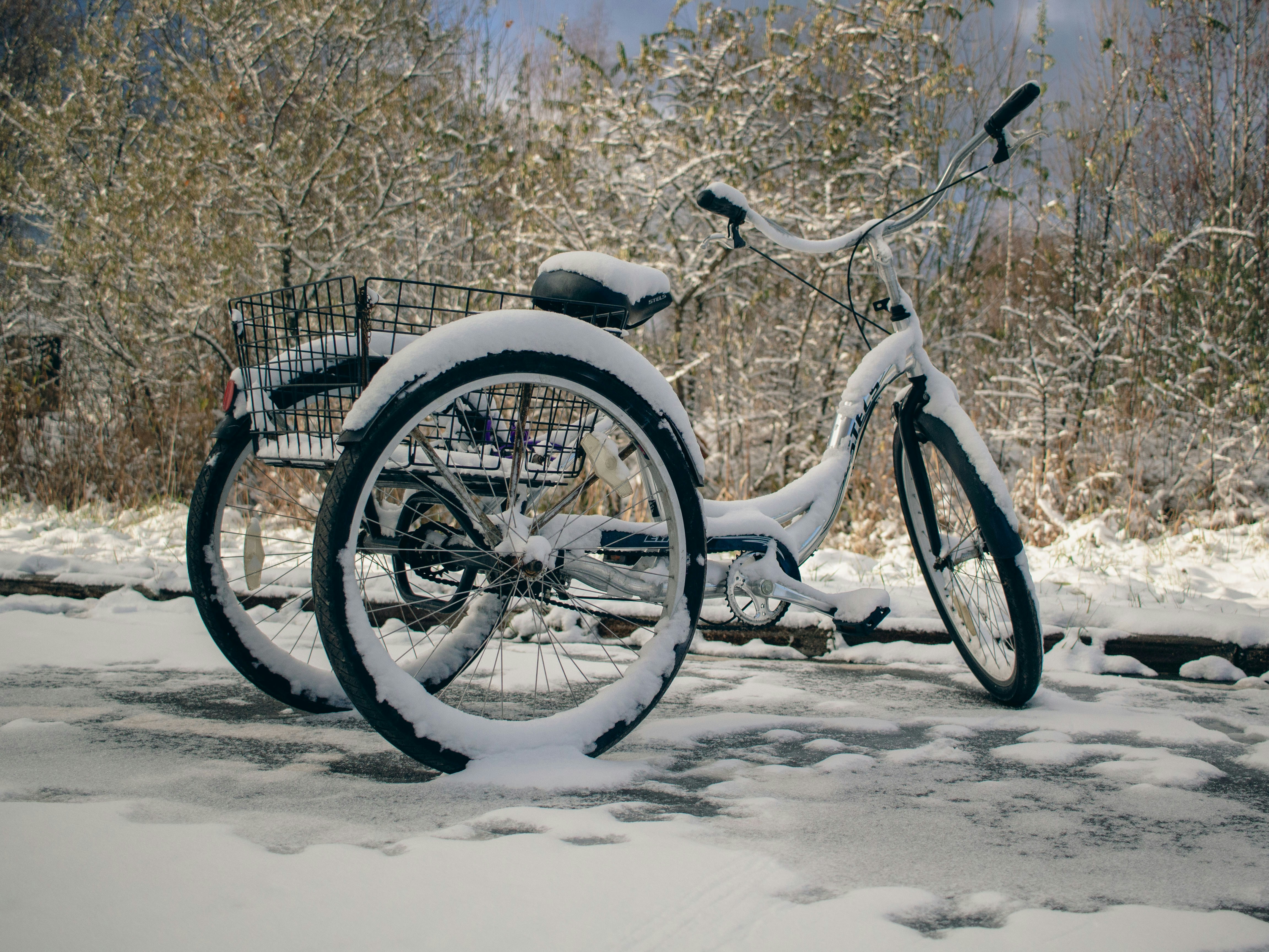 A snow covered bike parked in the snow