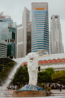 A statue of a woman holding a baby in front of a cityscape