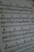 A sheet of music is hanging on a wall