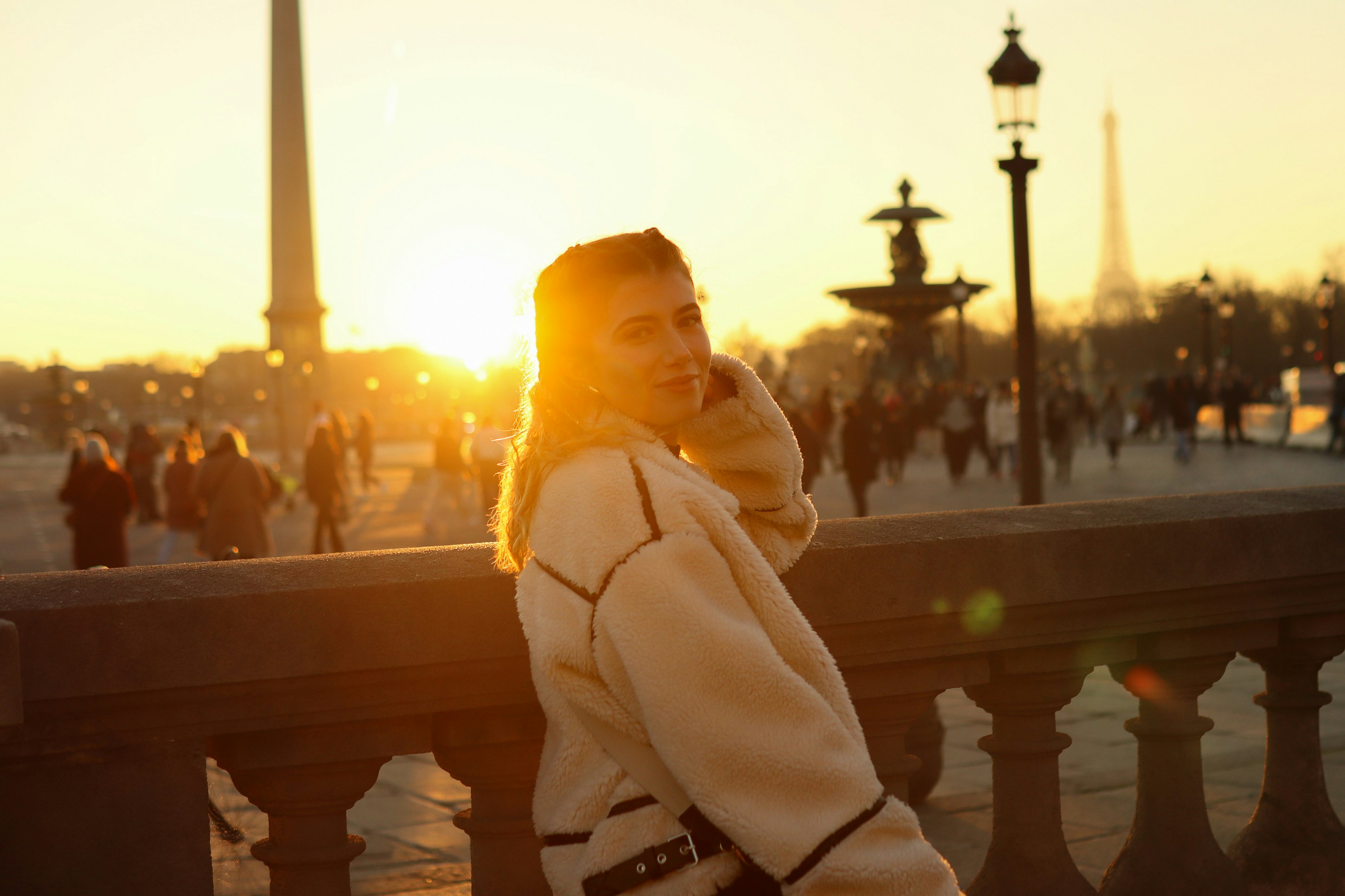 A woman standing on a bridge talking on a cell phone, 