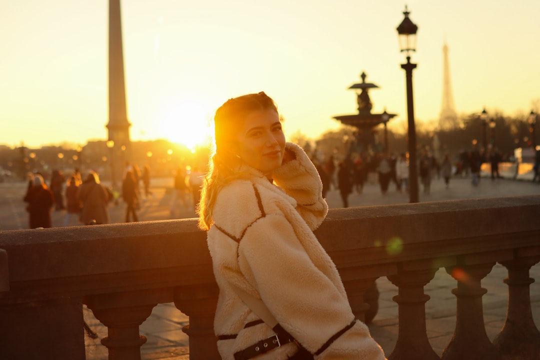 A woman standing on a bridge talking on a cell phone,
