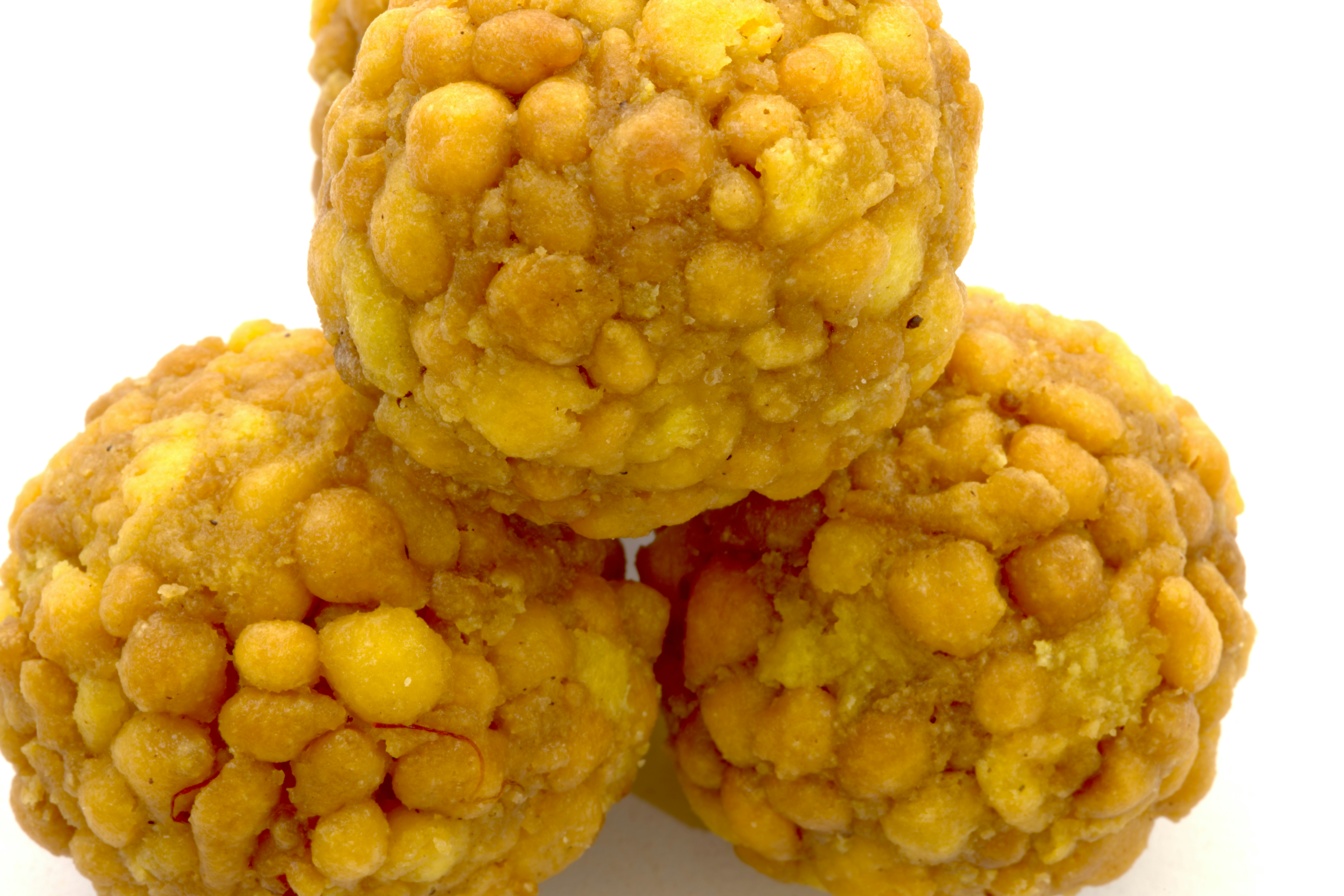 Round traditional Indian sweets laddoo on a decorative plate with warm golden lighting