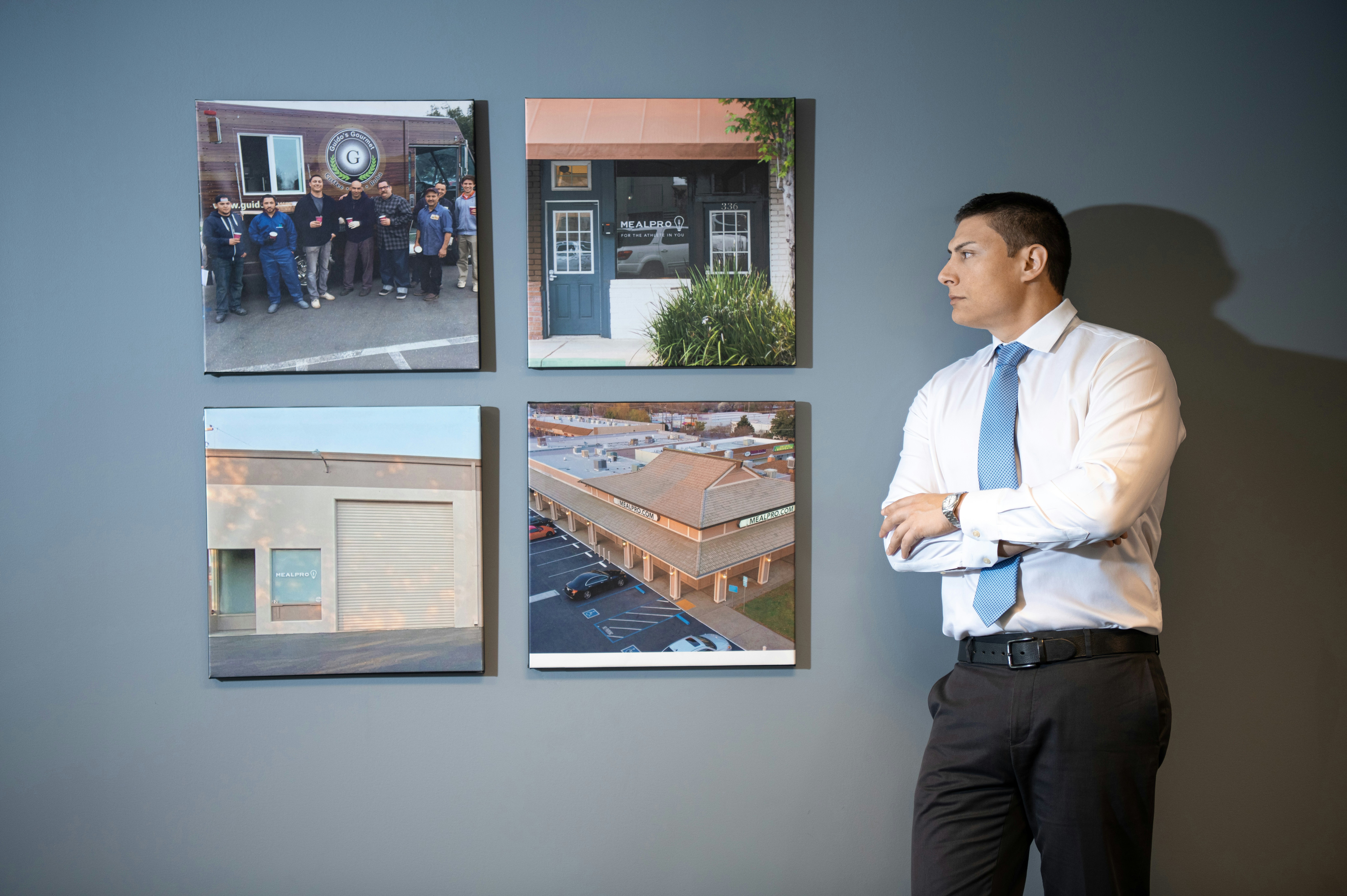 A man standing in front of a wall with pictures on it