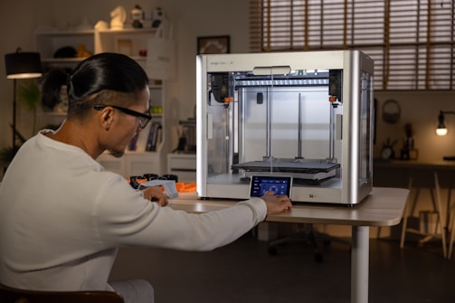 A woman is working on a 3D printer