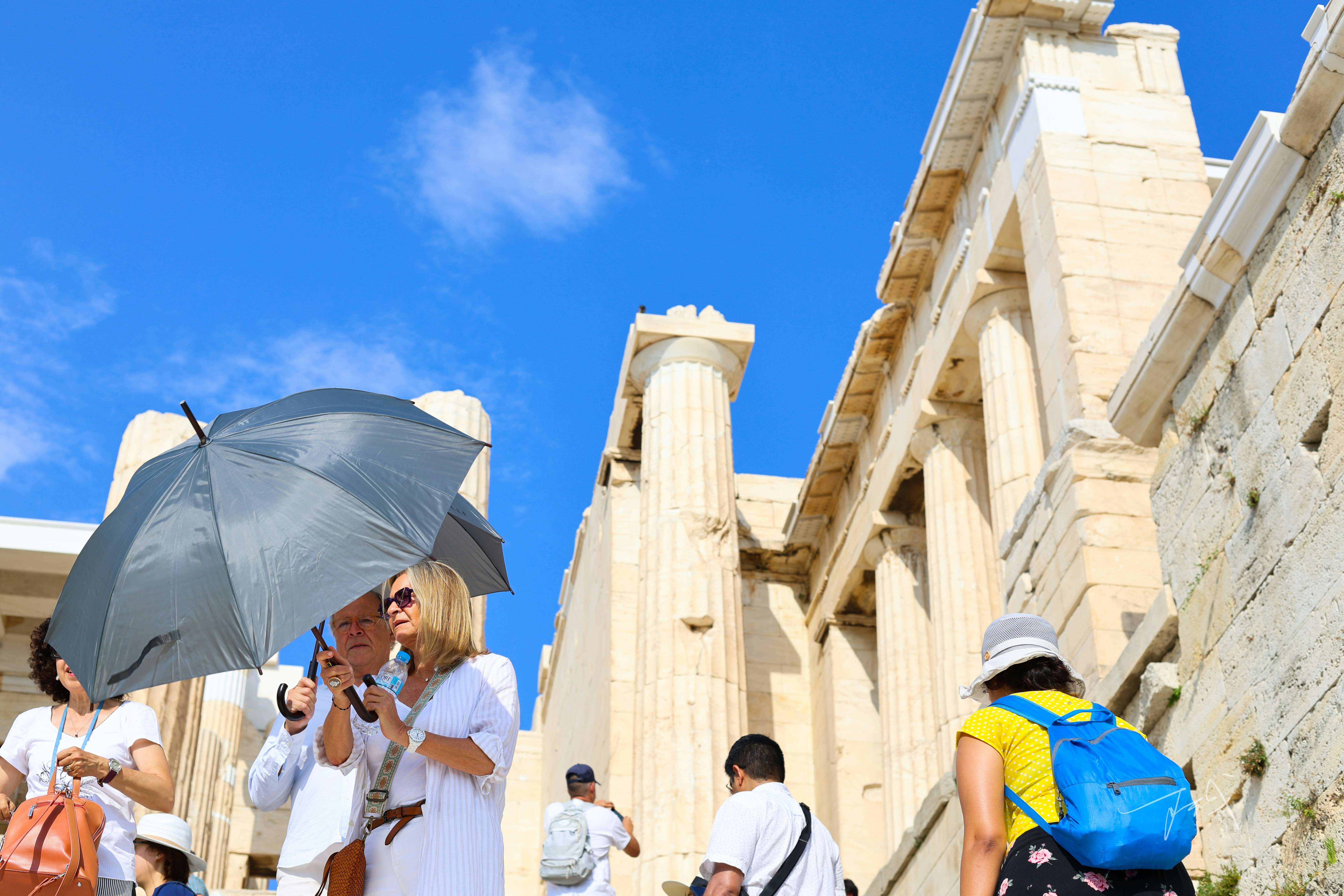 Group of visitors discovering the architectural wonders of the Acropolis during a sunny guided tour