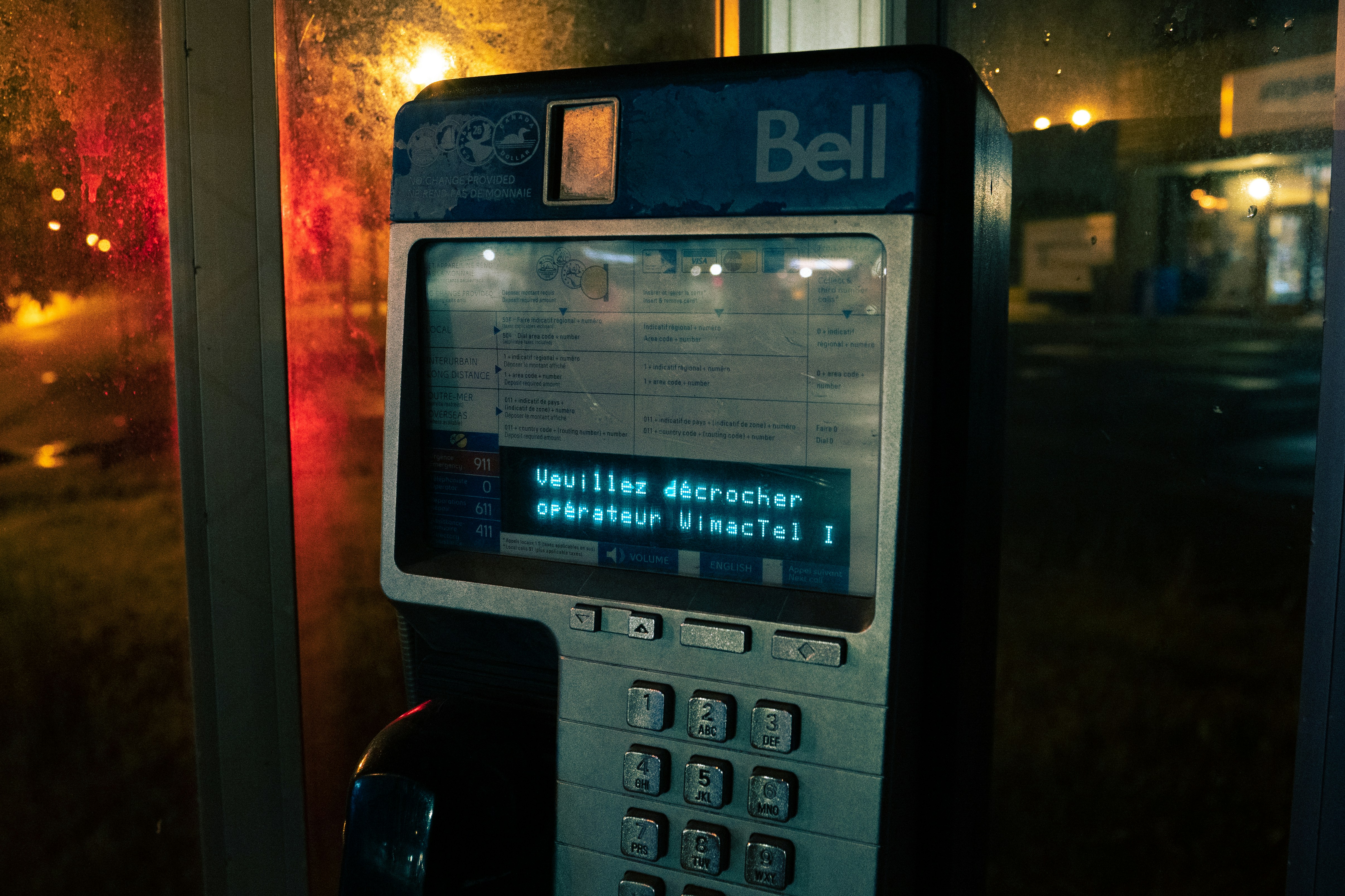 A cell phone sitting next to a window at night