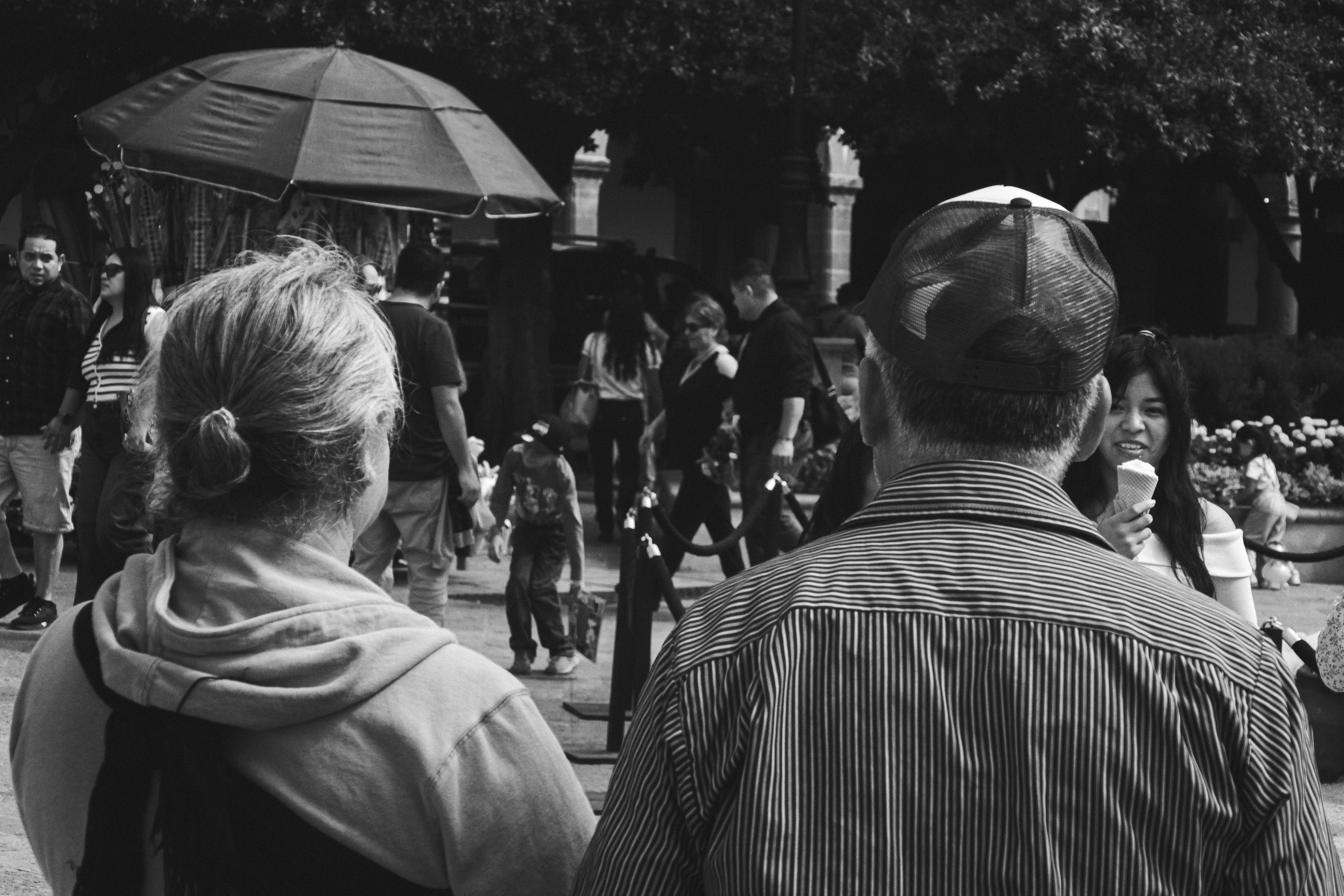 A black and white photo of people walking down a street