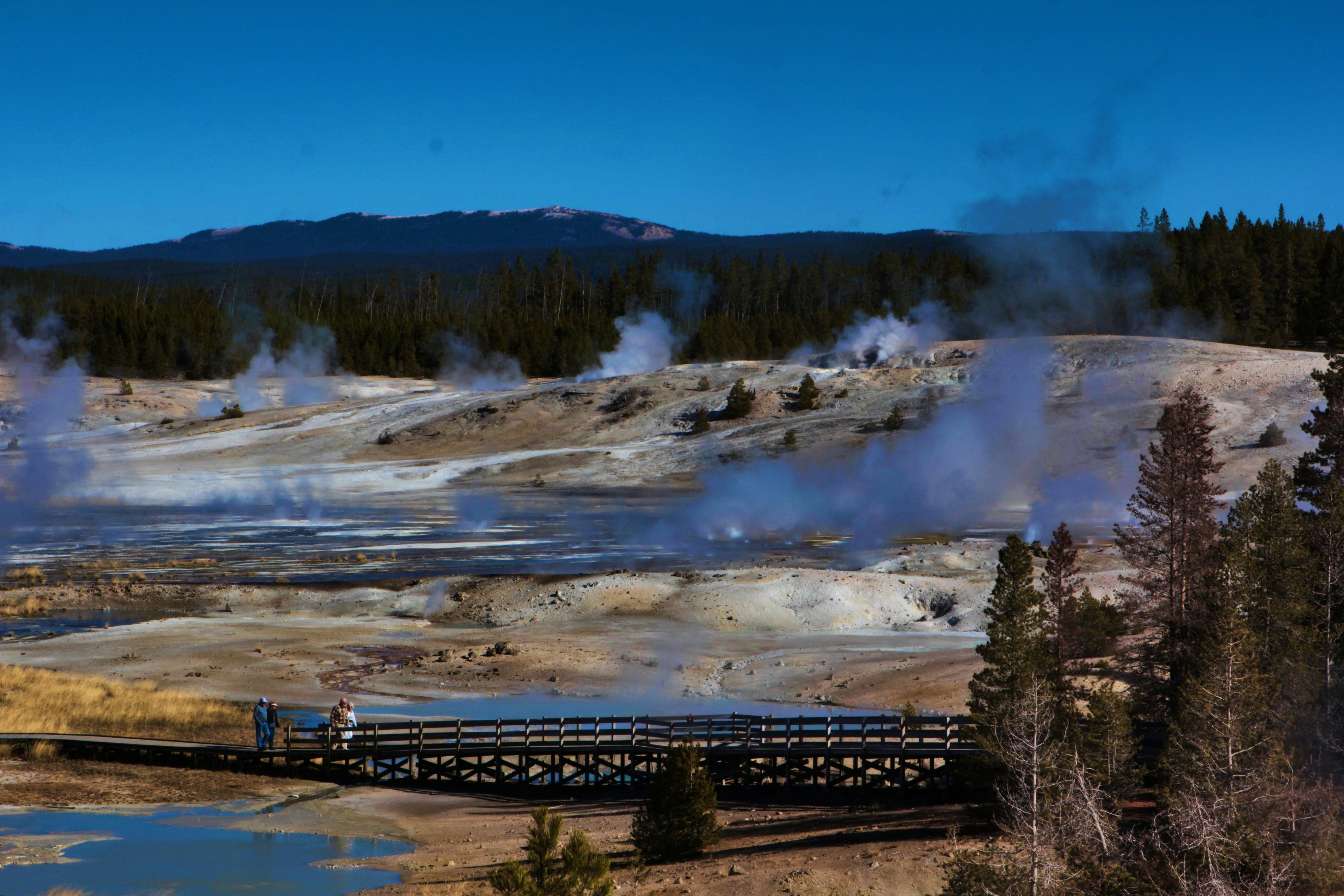 People walk along a boardwalk in Norris Geyser Basin in Yellowstone State Park in Wyoming, USA, October, 2024.