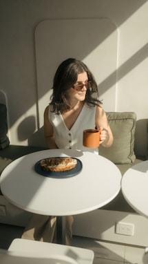 A woman sitting at a table with a cup of coffee