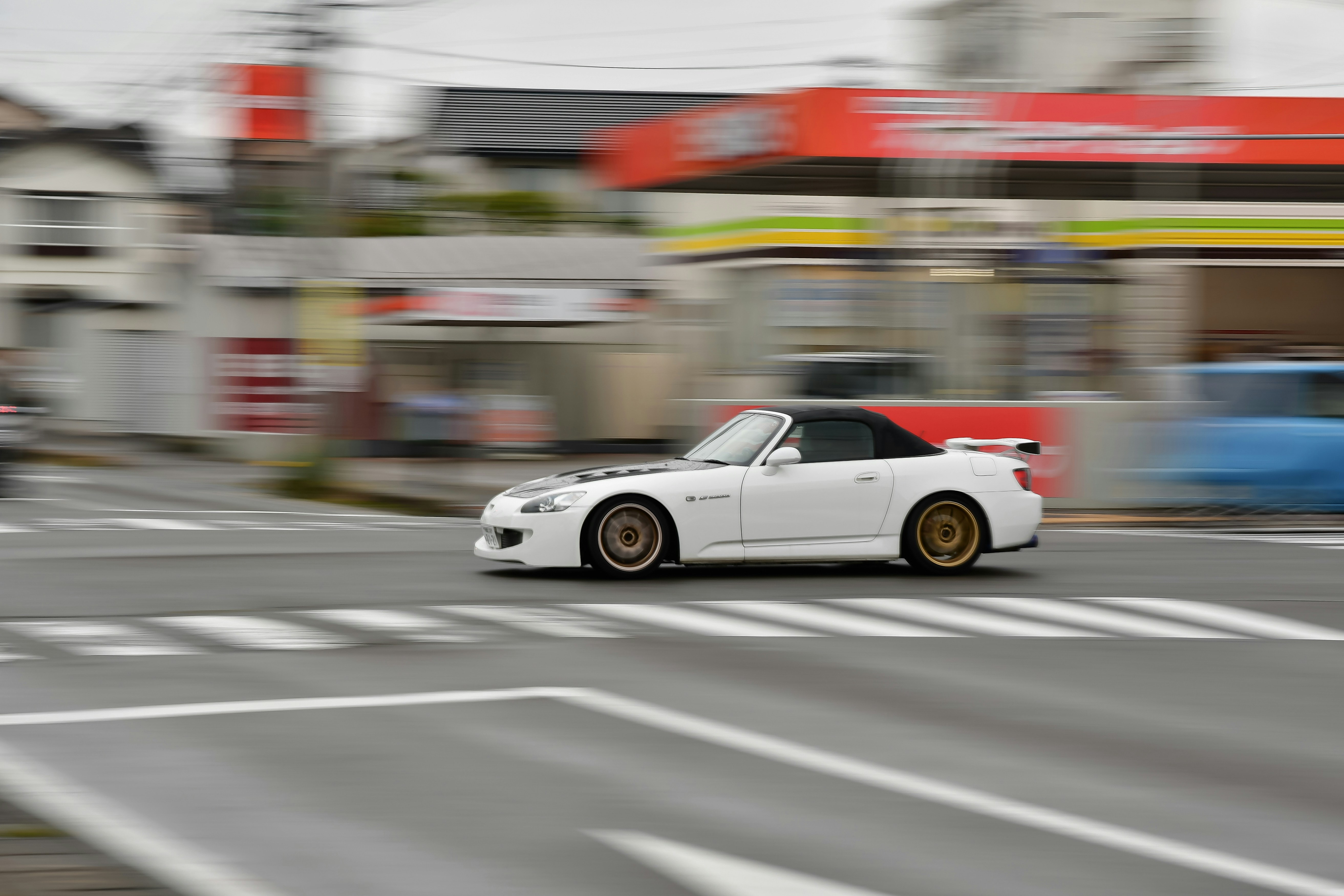 通りを走る白いスポーツカー