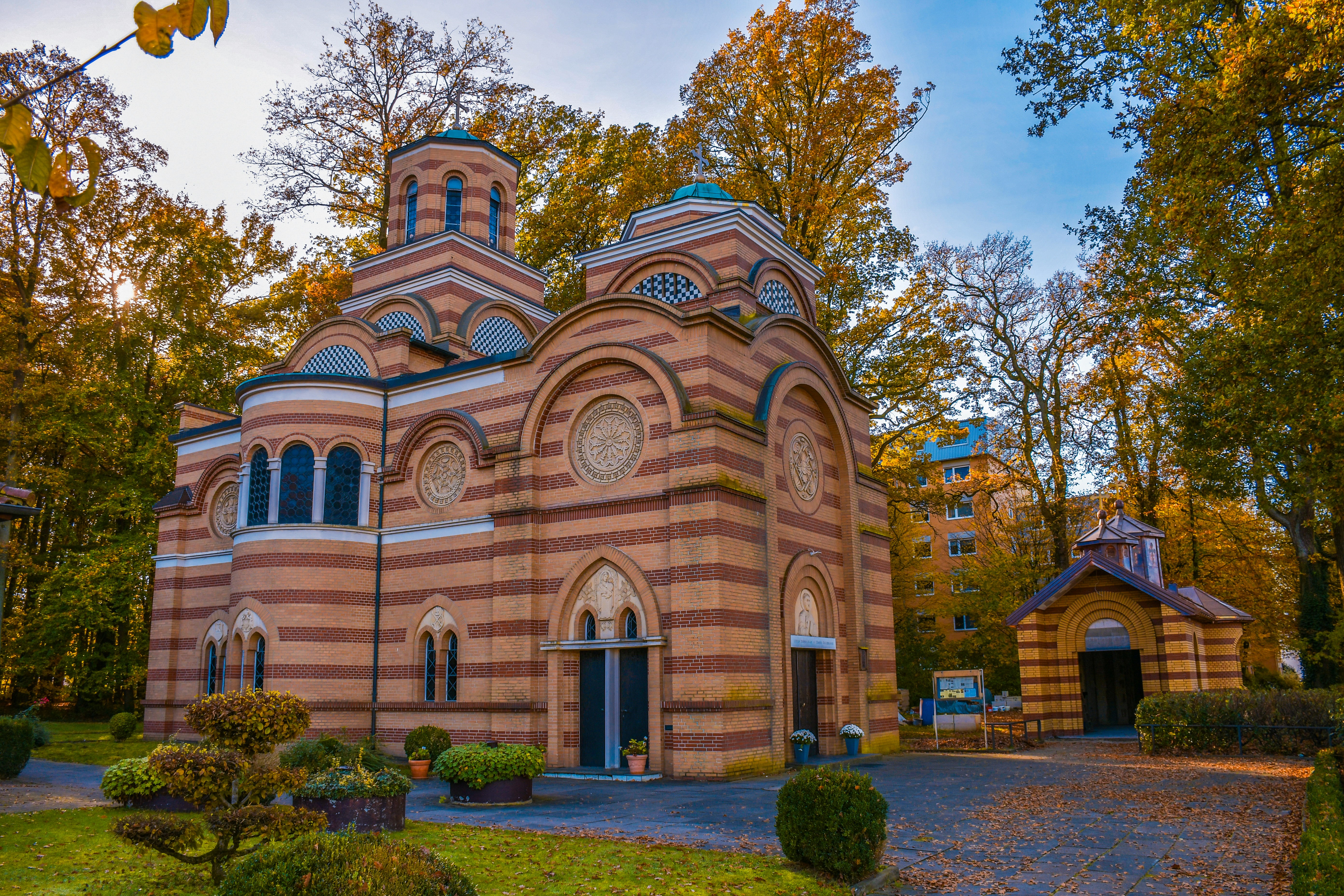 A church in the middle of a park surrounded by trees