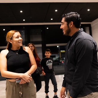 A group of people standing around talking to each other