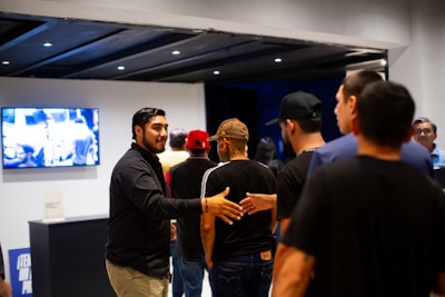 A group of men standing around each other in a room