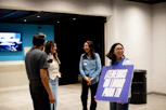 A group of people standing in a room holding a sign