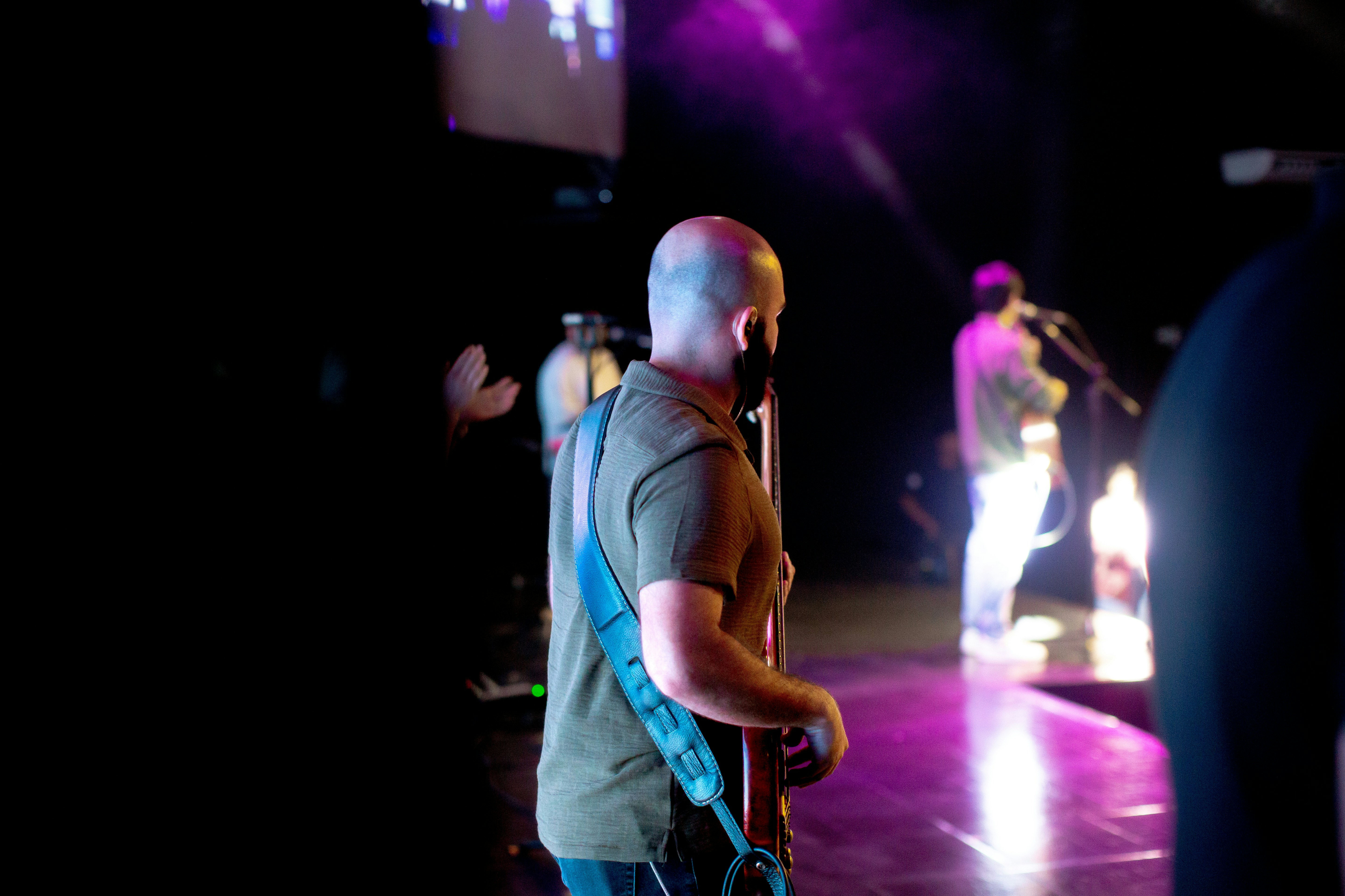 A man standing on a stage with a guitar