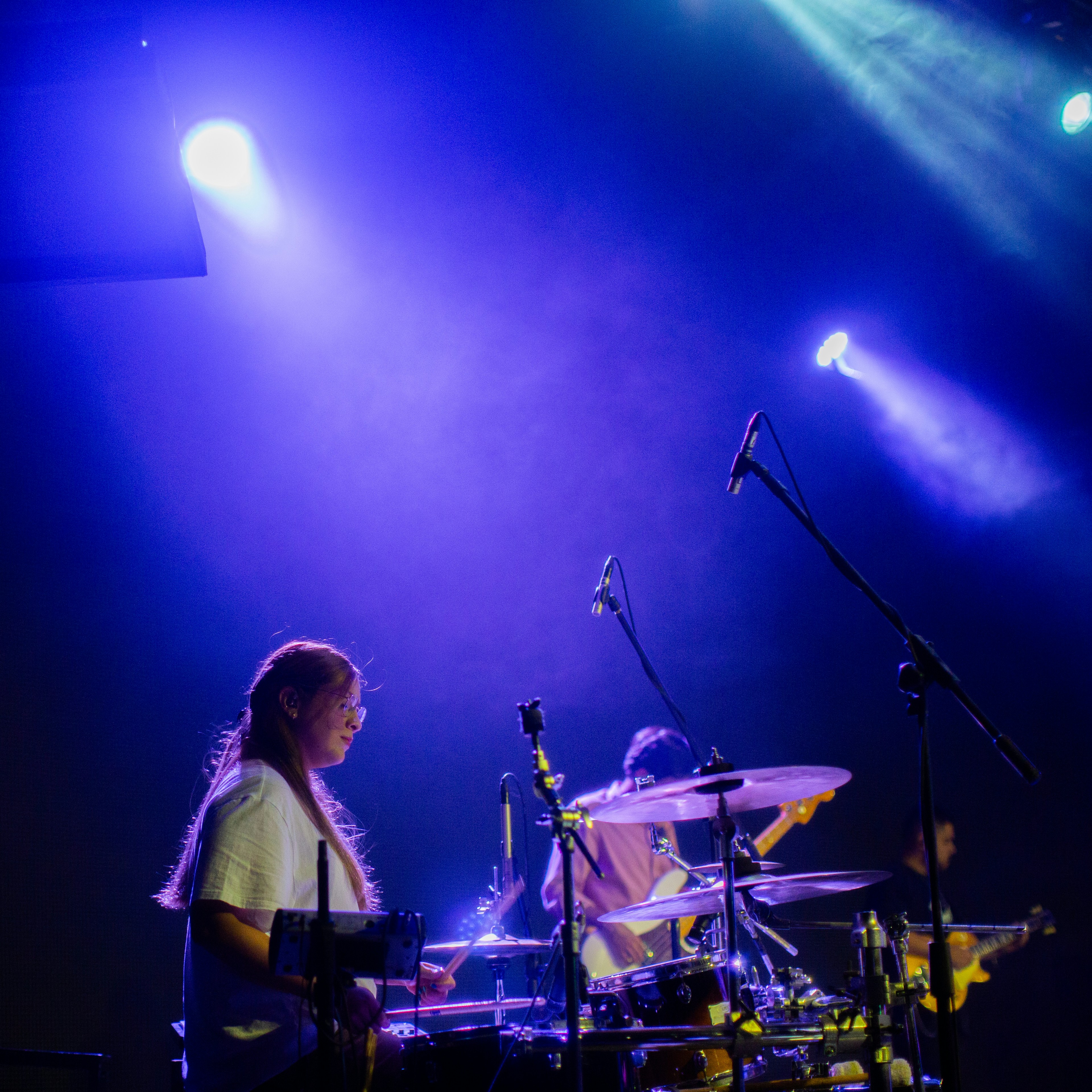 A woman is playing drums on a stage