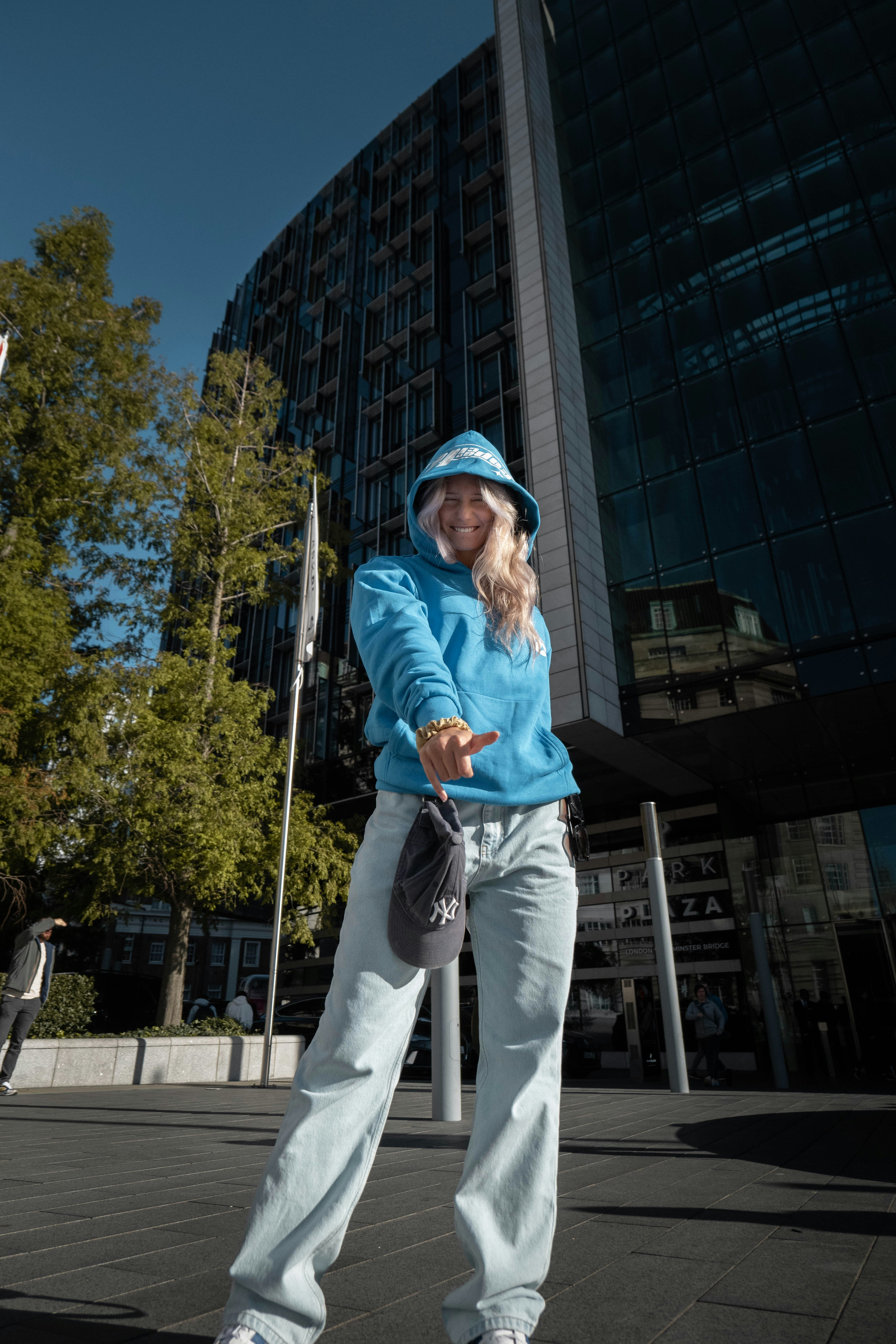 Una mujer montando una patineta frente a un edificio alto