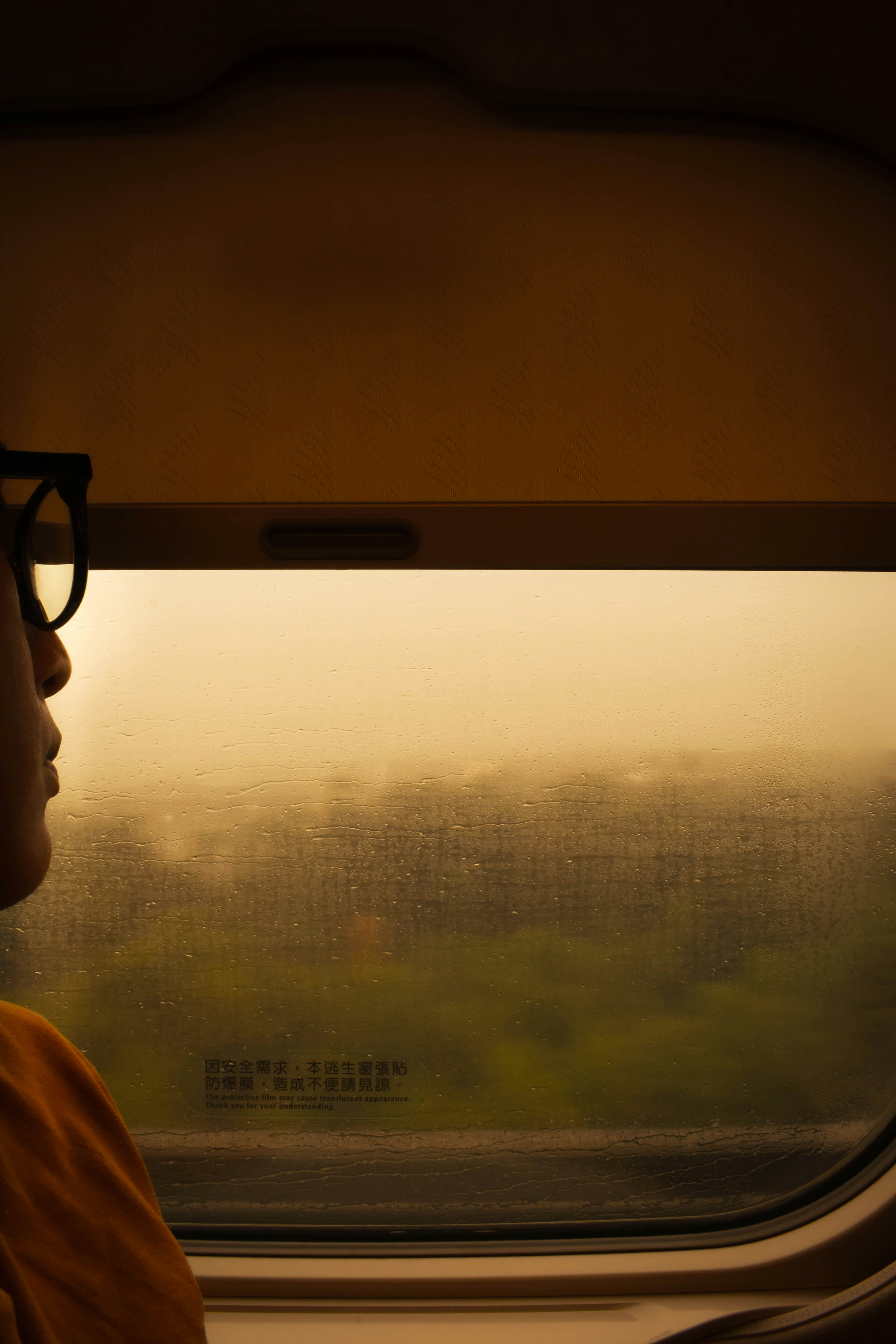 A person looking out a window on a train