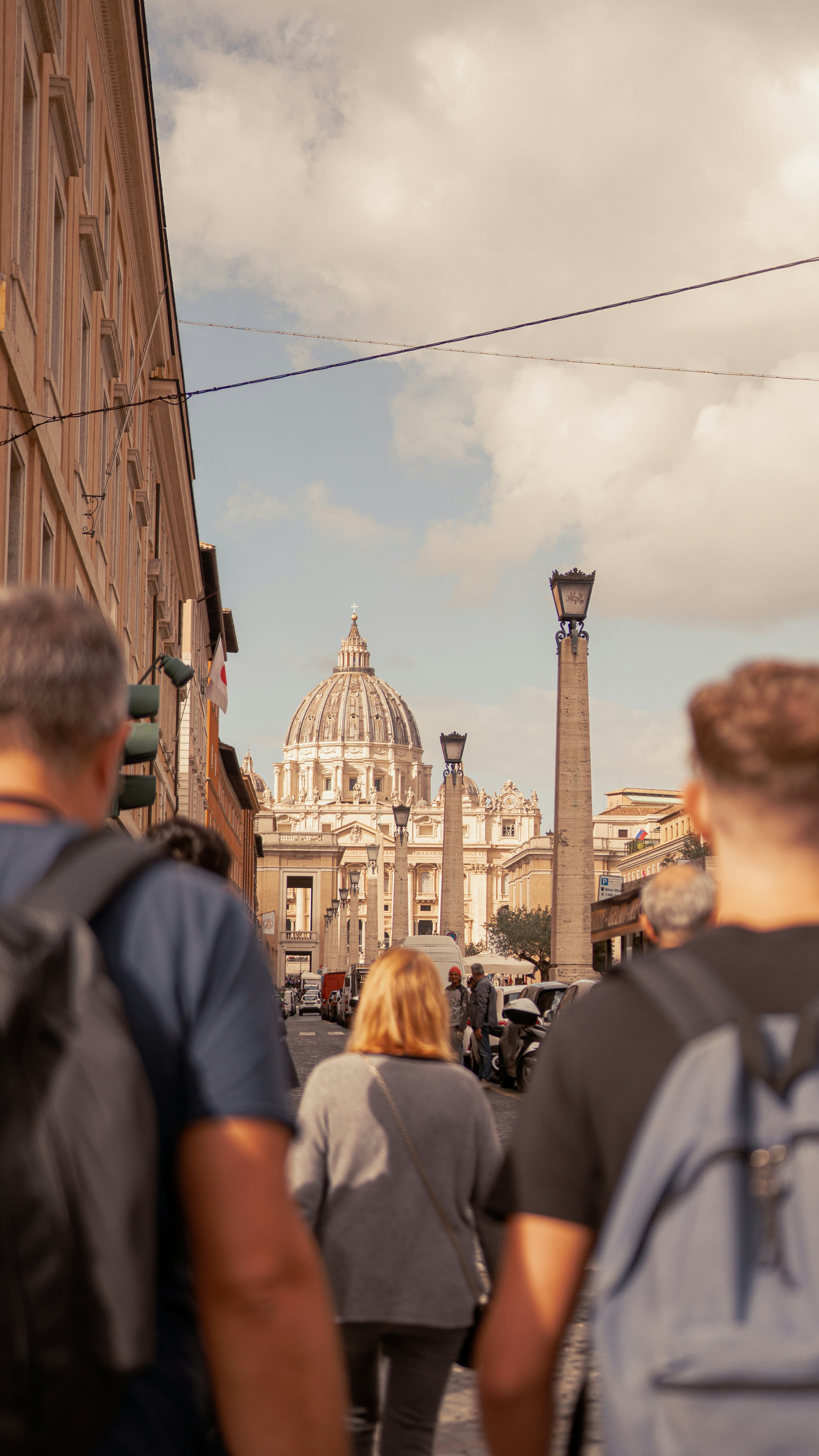 Eine Gruppe von Menschen geht eine Straße neben hohen Gebäuden entlang