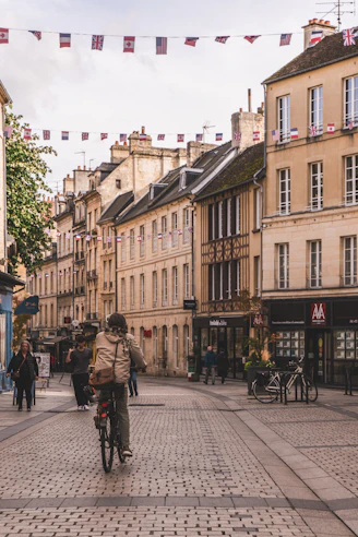 A man riding a bike down a street next to tall buildings