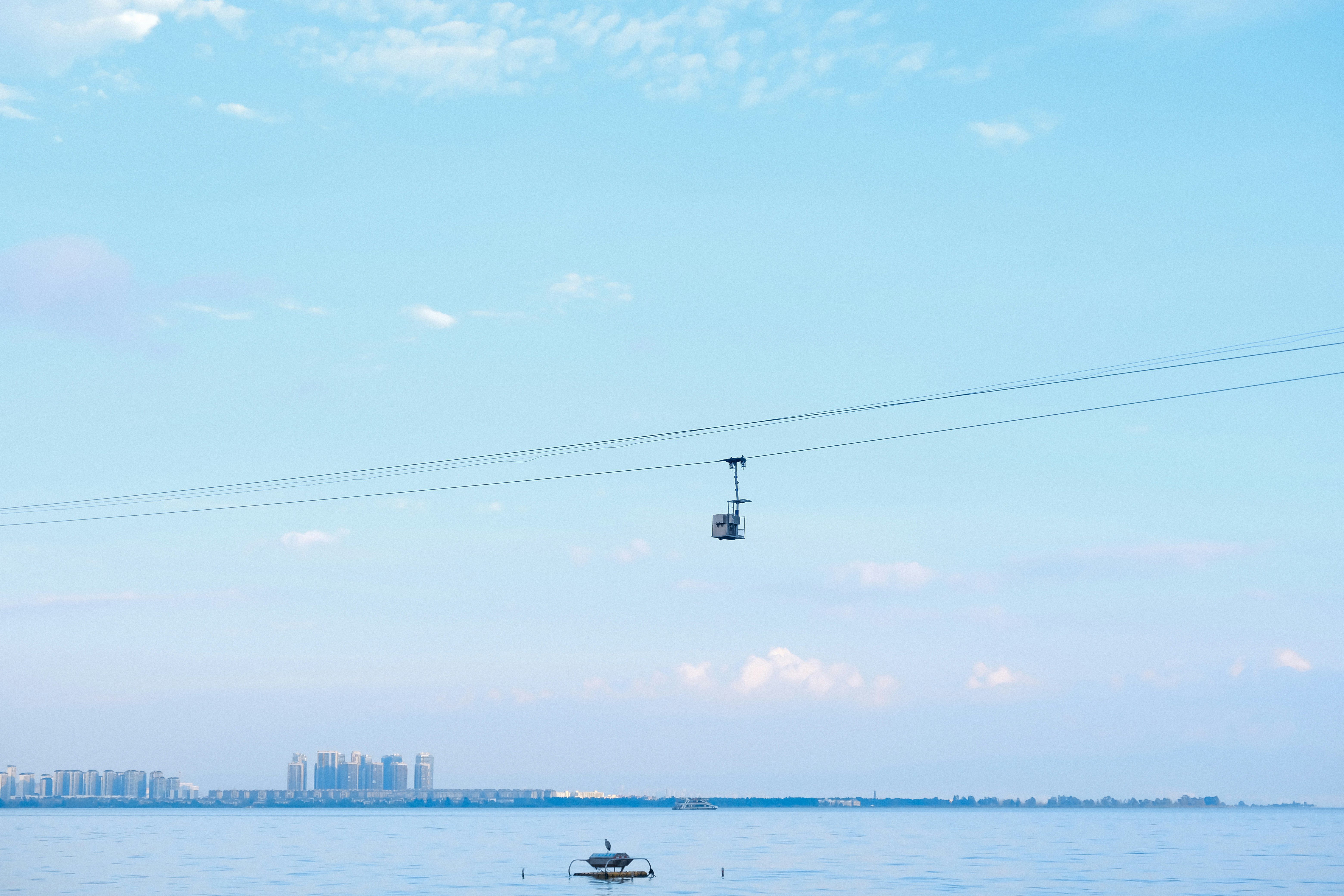 A view of a body of water with a sky lift in the background