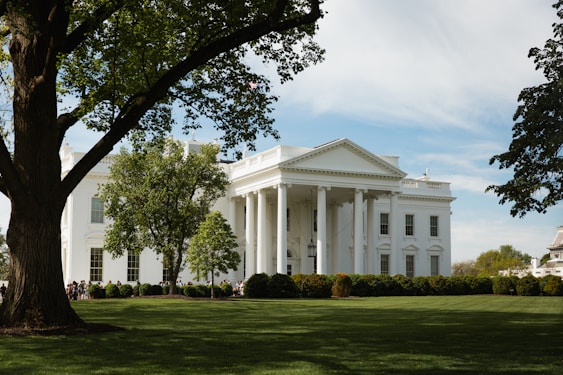 A large white building sitting on top of a lush green field