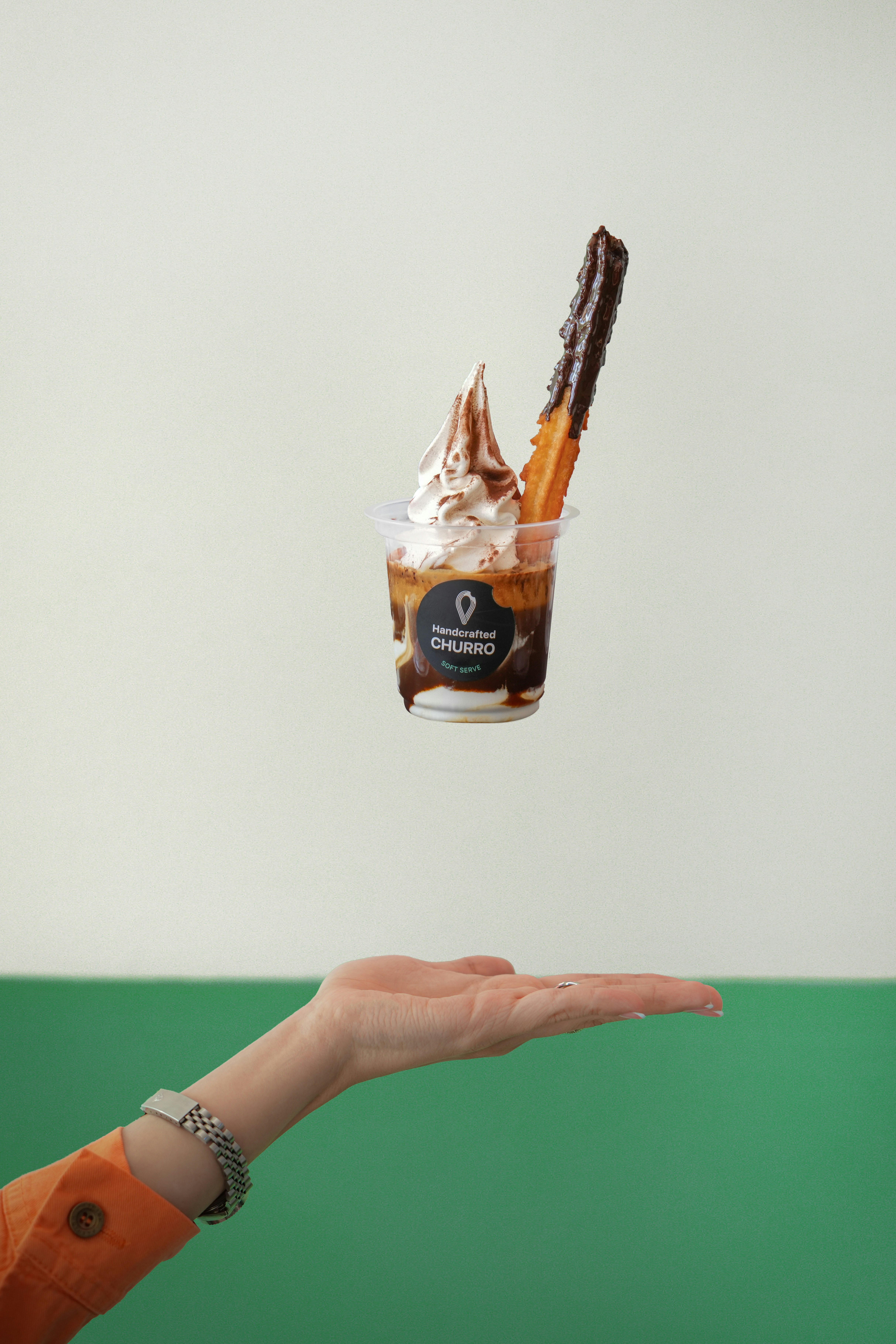 A person holding a cup of ice cream and chocolate