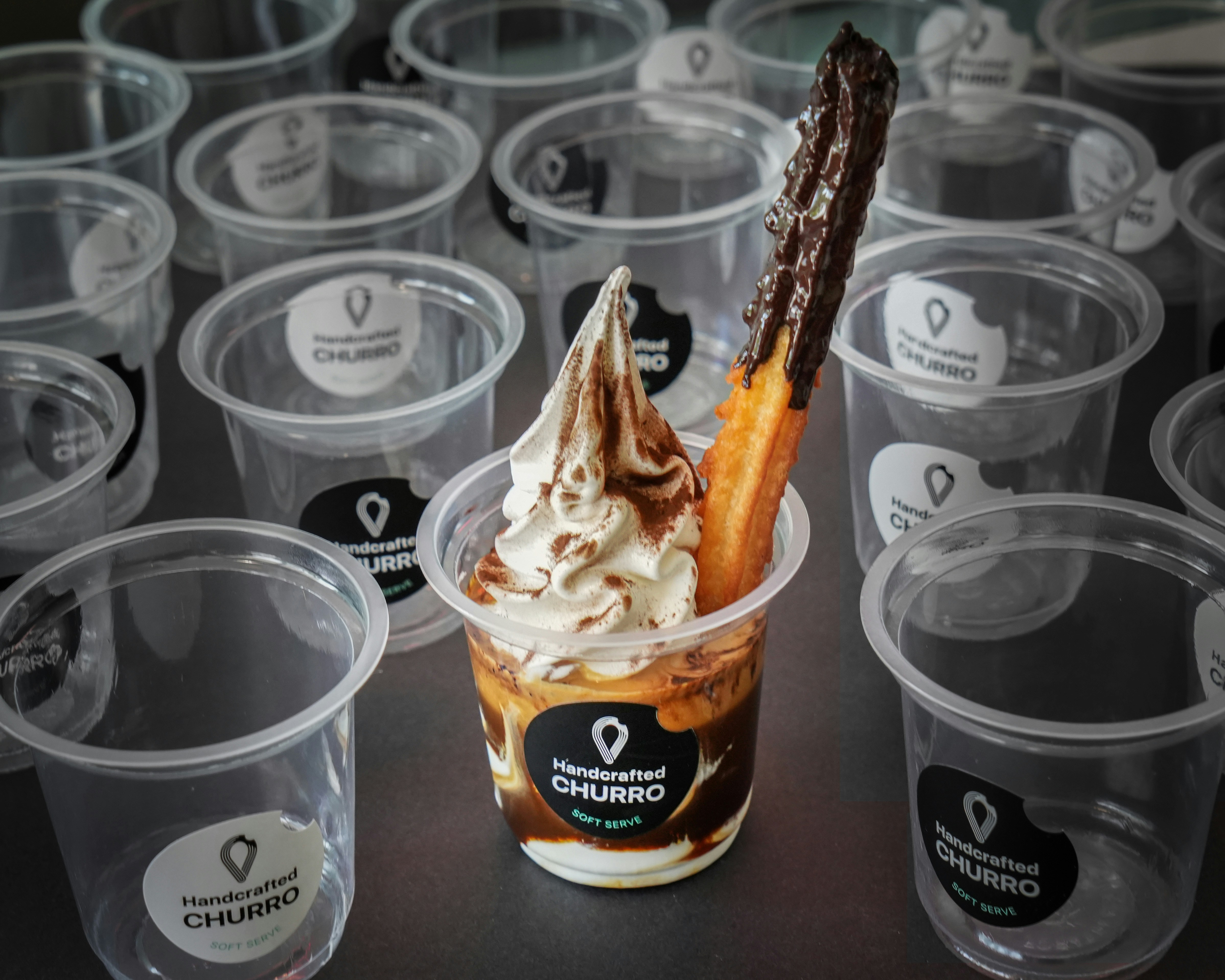 A table topped with plastic cups filled with ice cream