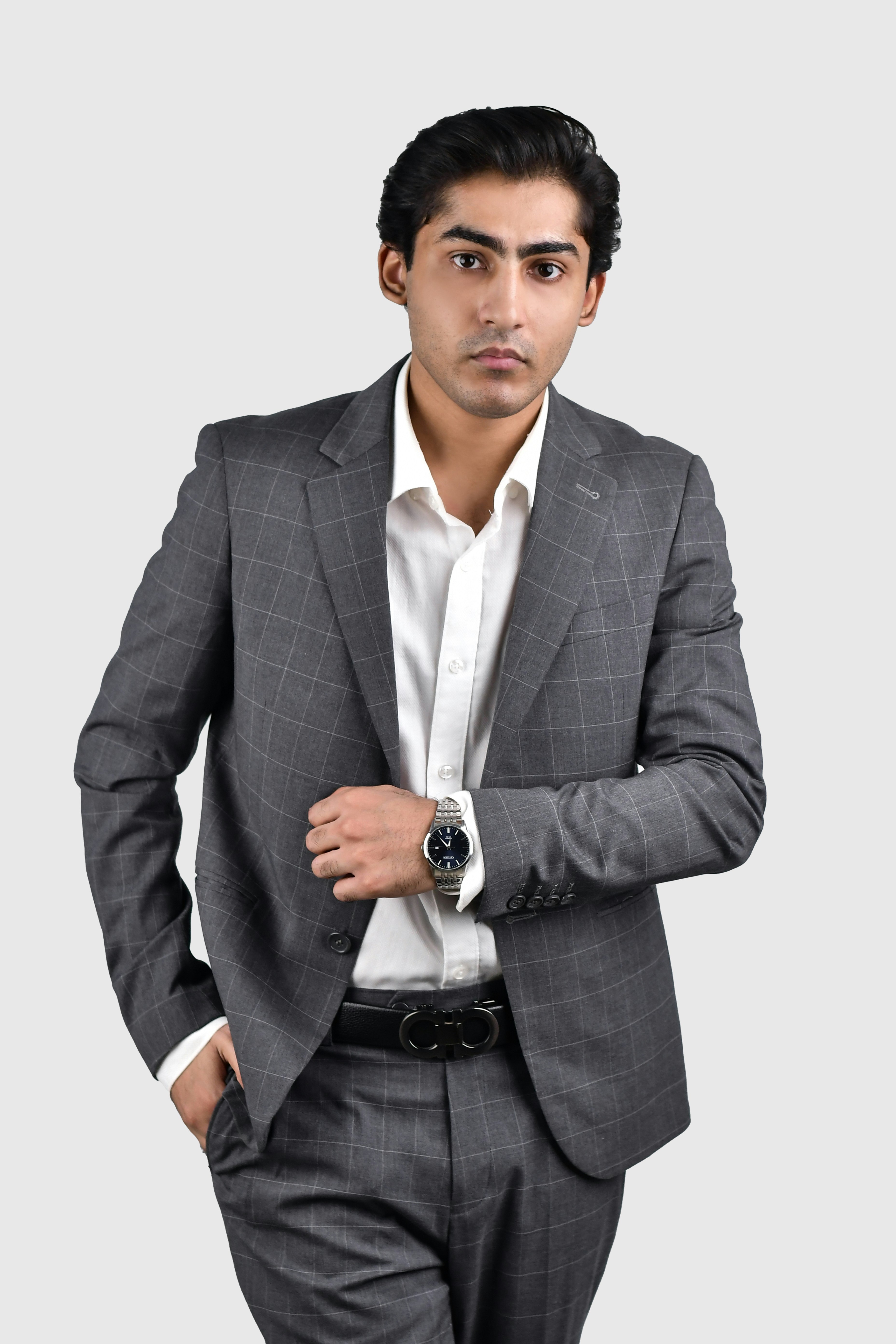 A man in a suit standing with his hands in his pockets