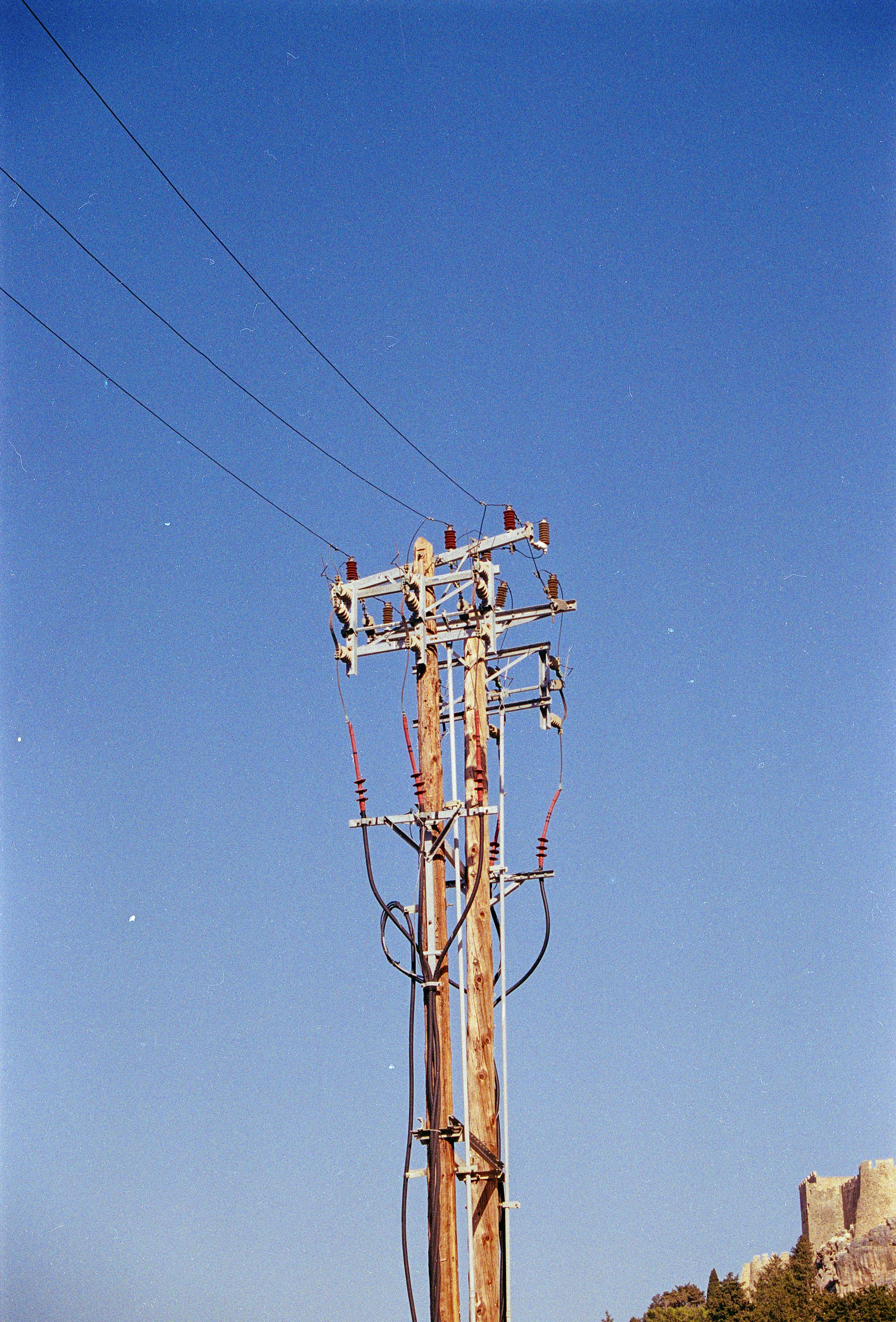 A tall wooden pole with a lot of wires on top of it