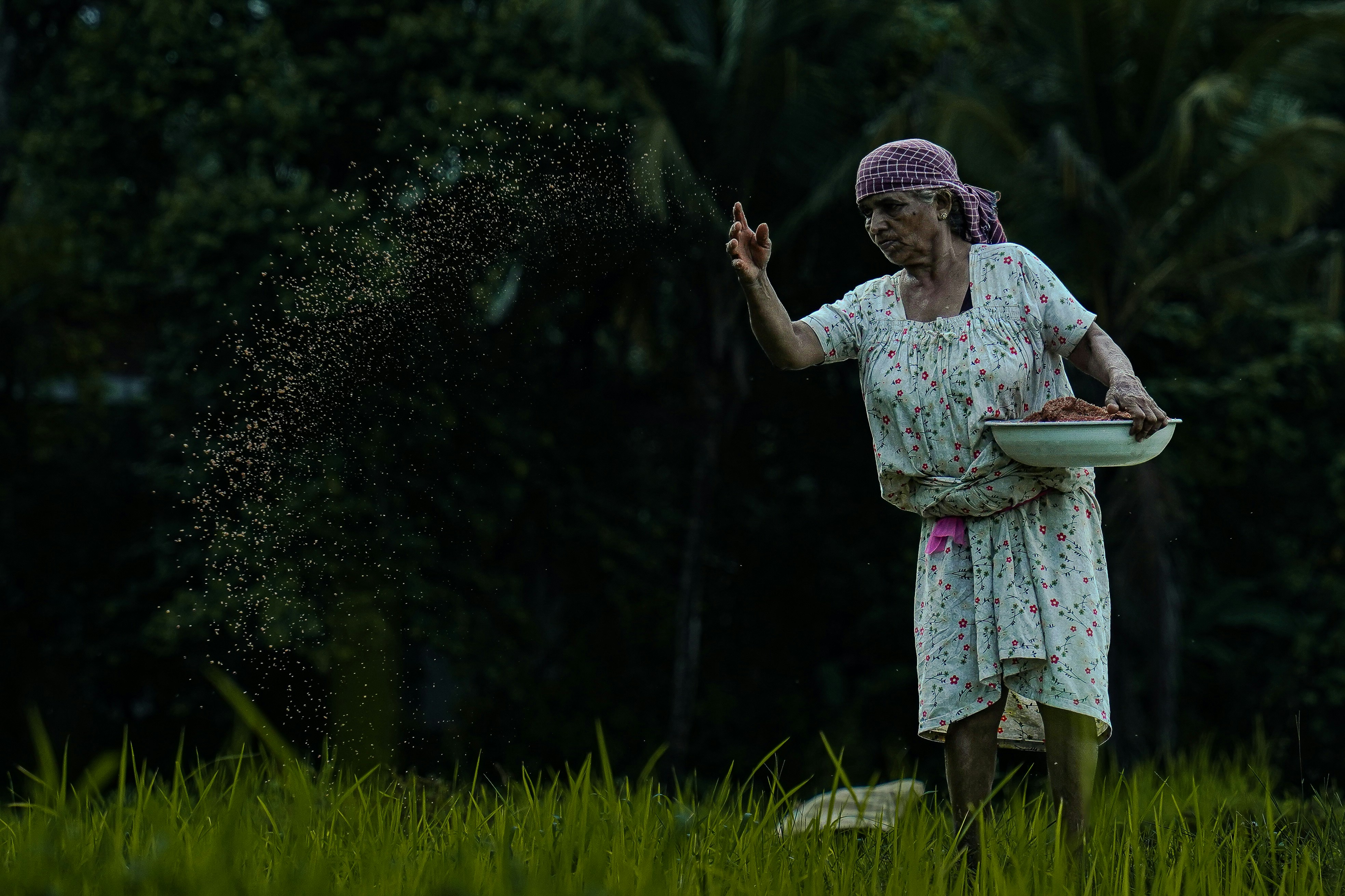A woman in a white dress is throwing sand into the air