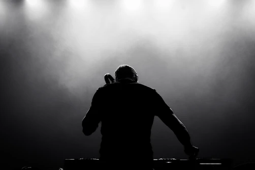 A dj in front of spotlights on a stage