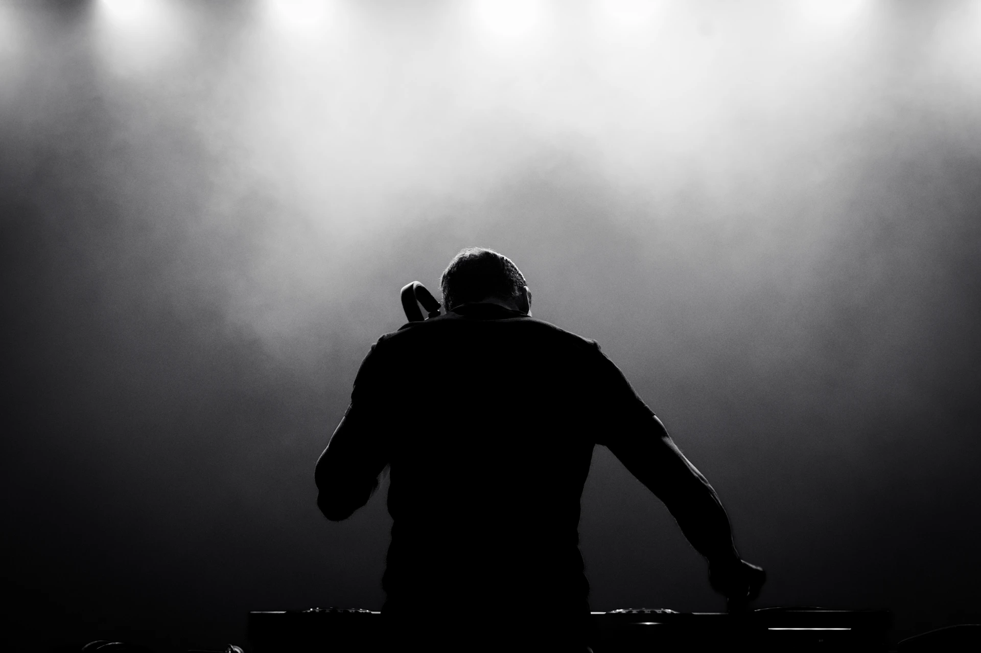 A dj in front of spotlights on a stage