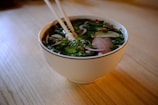 A bowl of soup with chopsticks in it